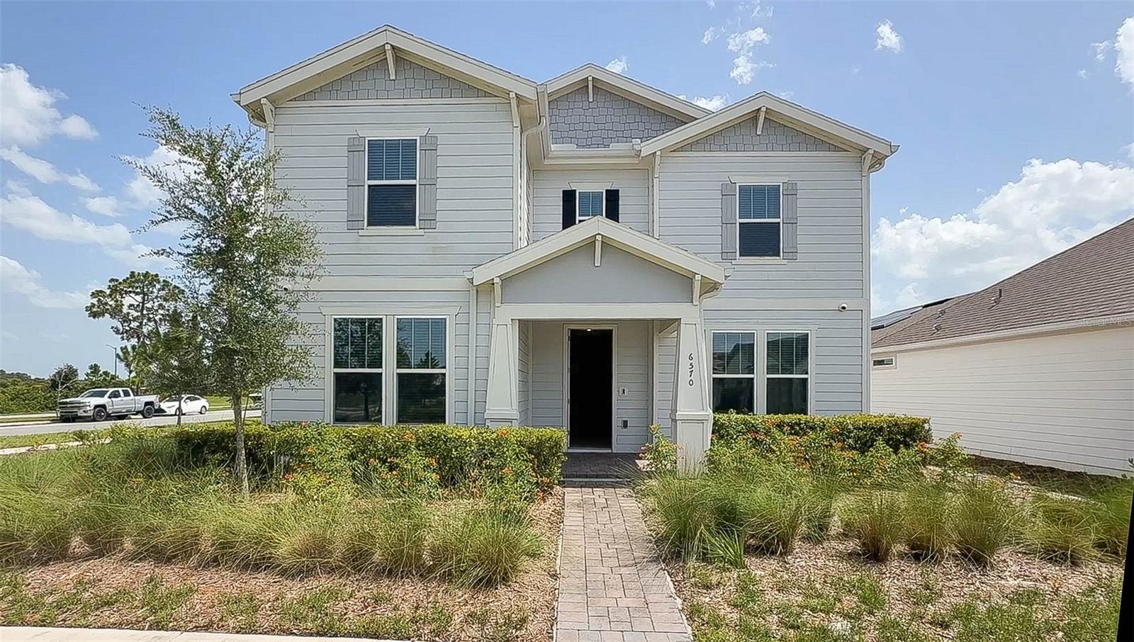 Virtually Staged. Located in the highly sought-after Weslyn Park at Sunbridge, this beautifully upgraded home offers a versatile floor plan featuring 4 bedrooms, 3 full baths, a first-floor flex room with double glass French door entry, and an expansive upstairs loft. A first-floor bedroom and adjacent full bath provide the perfect setup for guests or multigenerational living, while the flex room is ideal for a home office, playroom, fitness room, or media room and features an oversized under-stair storage closet. At the heart of the home is a gourmet kitchen featuring quartz countertops, an oversized counter-height island with abundant storage, built-in wall oven and microwave, cooktop with stainless vent hood, walk-in pantry, and abundant cabinetry overlooking the spacious family and dining areas. Hard-surface flooring extends throughout the home with wood-look tile on the first floor and luxury vinyl plank throughout the stairs and second level. Upstairs, the spacious loft provides additional living space, while each of the bedrooms enjoys beautiful water and/or conservation views. The primary suite serves as a peaceful retreat complete with an oversized walk-in closet and a luxurious bath featuring dual vanities, a soaking tub, and an oversized walk-in shower. Two additional bedrooms, a full bath, and a spacious laundry room with built-in cabinetry, utility sink, and a television wired to the home's exterior security camera system complete the second floor. Enjoy outdoor living on the extended paver lanai, while the air-conditioned two-car garage with an epoxy floor is conveniently connected to the home by a covered paver breezeway. Additional features include Tesla solar panels, keyless entry, a paver driveway, and lawn care is included. Residents of Weslyn Park enjoy resort-style amenities including a community pool, clubhouse, playgrounds, parks, walking and biking trails, and beautiful green spaces, all within the award-winning Sunbridge community. Conveniently located just minutes from Lake Nona Medical City, Orlando International Airport, SR 417, the Florida Turnpike, shopping, dining, and top-rated schools, this exceptional home offers the perfect combination of comfort, convenience, and low-maintenance living.
