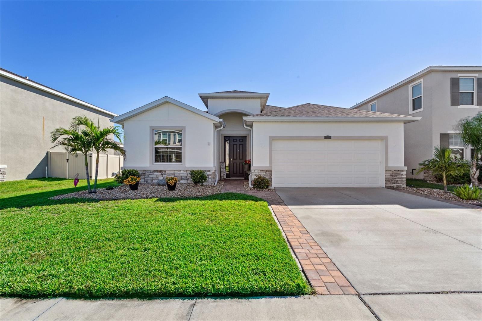 Enjoy beautiful sunrises in the morning with this stunning 4 bedroom/2.5 bedroom home located in the heart of Epperson Crystal Lagoon, all while enjoying a resort style living.  This block home faces west, allowing for a perfect eastern view from it's oversized lanai providing beautiful shade for the majority  of the day - perfect for cocktails and grilling while enjoying the beautiful water view.  It features a spacious split floor plan with several interior upgrades including large light colored ceramic tiles throughout; granite counter tops in the kitchen and bathrooms; a large primary suite with windows that overlook the pristine pond views.  In the two car garage, you will find a stainless steel utility sink and the driveway has been expanded with pavers to allow extra parking; the back yard is completely fenced in with beautiful mature palm trees.  There is a metered irrigation system in the front yard with a drip system in the back.  Gutters were added around the entire property in 2022.  All appliances were new as of 2021.  
The resort style community features a tropical oasis with a 7 acre, family and adult friendly, crystal lagoon; complete with sandy beach areas, a swim-up bar, kayaking, paddle boarding, beach volleyball courts, a large water slide, inflatable water activities, swim up bar, and so much more.  The neighborhood also features trails, a dog park, a shaded tot lot, and golf cart paths. Plus, there's a new K-8 Charter School.
Ask the listing agent about the low rate  assumable loan opportunity.