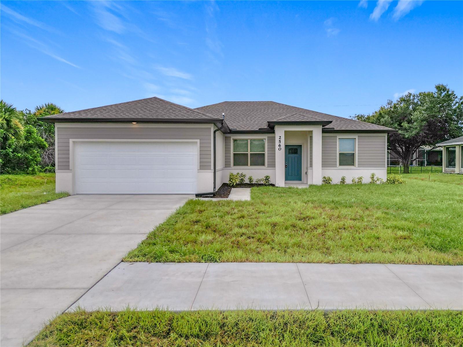Excellent price with luxury features and move-in ready! A brand new home with CITY WATER AND SEWER in North Port – no HOA fees! Great location! Ideally located for quick access to Highway 41, shopping, schools, medical facilities, Warm Springs Park, and the Aquatic Park. This affordable new home is ready for you and is just what you've been looking for... No HOA fees and city water! This home features 9-foot ceilings, a spacious and open layout with a versatile floor plan. The home has 4 bedrooms, 2 full bathrooms, a formal dining room, a living room, an open kitchen, and a two-car garage, with 1,810 square feet of living space. The living space is well-utilized, with high ceilings and numerous windows providing natural light. The interior finishes will provide you with the quality and luxury you were looking for in your new home. This home has a split floor plan, with the primary suite on one side and the guest bedrooms on the other. The primary bedroom has tray ceiling and large windows allowing for plenty of natural light. You will also enjoy a spa-like bathroom with a spacious walk-in shower with floor-to-ceiling tiled walls and a glass enclosure. It also features a linen closet, a double vanity, and a large walk-in closet. The living room has large windows and several LED light fixtures providing ample light, with access to the covered lanai. The living room is open to the kitchen, where you will find a large center island with additional seating for casual dining and plenty of cabinetry. The kitchen features stainless steel appliances, Shaker-style cabinets with crown molding , decorative hardware, a subway tile backsplash, and granite countertops. The dining room is located at the front of the house, with large windows allowing for abundant natural light. The home includes luxury vinyl plank flooring in the main living areas and bathrooms for durability and comfort. You'll love these floors! They are easy to maintain and offer a modern design, perfect for new homes. Other features include the same beautiful Shaker-style cabinets with hardware and granite countertops in the bathrooms, 5-inch baseboards, a garage door opener, exterior gutters, R38 insulation, a 16 SEER HVAC system, and much more. Visit our showroom and compare the features and quality to other homes, and you'll see the difference. We make buying easy for you! The photos and videos are the same floor plan, but different location.