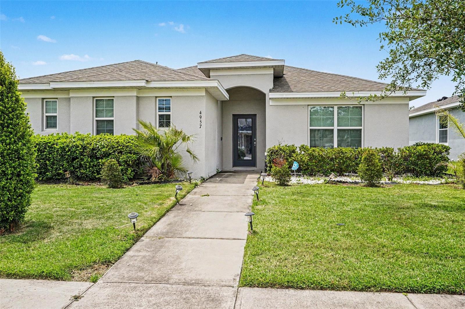 One or more photo(s) has been virtually staged. Escape into your private sanctuary at 4957 Castle St. E, and enjoy effortless, resort-style living. Centered within the highly coveted, 24-hour guard-gated community of Trafalgar Village in Kissimmee, this stunning 4-bedroom, 2-bathroom residence is the epitome of turn-key perfection. Built in 2019 and meticulously maintained, this home welcomes you with an abundance of natural light dancing across gorgeous tile floors, evoking an immediate sense of calm and sophistication. Designed with a keen eye for organization and flow, the open-concept layout centers around a dream kitchen featuring pristine cabinetry, gleaming stainless steel appliances, and a beautiful central island meant for effortless hosting. The split-bedroom floor plan ensures ultimate privacy, showcasing a serene primary suite complete with a massive walk-in closet and an en-suite bath with a double-sink vanity. Three additional guest bedrooms offer deep closets and endless versatility for a home office or creative space. Beyond your door, the HOA handles ground maintenance, allowing you full freedom to enjoy the community's lakefront clubhouse, resort-style pool, fitness center, and wooded walking trails. Located just minutes from world-class attractions, this is a flawless investment or forever home.