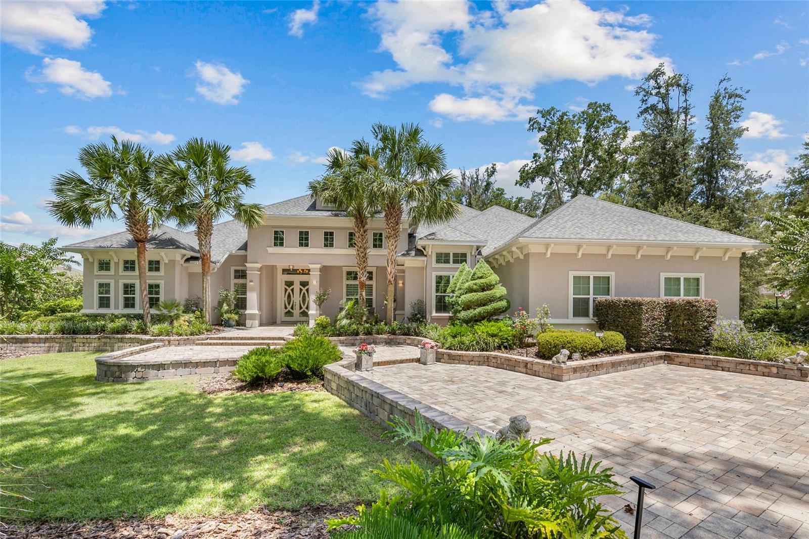 Experience timeless elegance and modern sophistication in this exquisite French Contemporary home by Jeffrey M. Wilde Builders, Inc. where each room holds intricate interior design details directed by the home owners. Nestled on a lushly landscaped private 1-acre lot in SW Gainesville’s highly desired Oakmont community, a circular driveway and expansive hardscape enhances the grand curb appeal and welcomes you to this 6-bedroom, 4.5-bath masterpiece, where every detail reflects refined craftsmanship, luxury, and comfort. This home’s tranquil setting features a serene pond, large community green space and natural wooded barrier at the rear of the home providing peaceful views and enhanced privacy. Designed with intentionality and refinement, the home features hand-scraped French oak wood floors, detailed trimwork and crown molding throughout, and abundant natural light from a desirable southern exposure. The gourmet kitchen is a chef’s dream, complete with a 42” built-in French-door Sub-Zero refrigerator, a 48” dual-fuel Wolf range with double ovens, French cooktop, and warming shelf, accompanied by bright cabinetry, custom marble backsplash, extra-thick quartz countertops and a dramatic mitered-edge marble island. The coffee bar has ample storage and a second Miele dishwasher, and a sunlit breakfast nook overlooking the backyard oasis provide a Florida resort feel. Entertain in style with a 500+ bottle wine cellar with a dedicated cooling system, a formal dining room featuring a chandelier imported from Paris, and expansive living areas perfect for both large gatherings and intimate moments. The luxurious primary suite on the main level offers style with a grasscloth wallpaper accent wall and encased, motorized blackout shades. The spa-inspired bathroom has oversized 18” marble flooring and walls, a “warming wall” leading to an expansive custom shower with rain shower heads and body sprayers, and a stunning soaking tub filled with natural light. Dual walk-in closets with custom built-ins, a linen closet and large dual vanity complete the primary bathroom. Additional first-floor highlights include three spacious guest bedrooms and two dual sink bathrooms, an eloquent powder room, a fully trimmed office with built-in shelving and cabinetry, and a large laundry room with a dedicated pet bath/boot shower. Upstairs, discover two additional bedrooms, including one ideal for an in-law suite with nearby kitchenette and an expansive media room with multi-screen wall—perfect for game days or Netflix movie nights! Outdoor living shines with a screened-in retreat featuring an oversized pool and spa with travertine decking, an outdoor fireplace, a gourmet summer kitchen with built-in grill, two-tap kegerator, seafood boil gas cooker, a zoned AV system for TV and audio throughout the space. The three-car garage is thoughtfully designed with a 250 AMP power for EV charging or equipment use, with one bay measuring 24’ deep with 14’ ceilings and a 6” slab—ideal for an auto storage lift. Located in Oakmont, Gainesville’s premier master-planned community spanning 550+ acres. Enjoy access to a Residents Club with resort-style pool and splash pad, a state-of-the-art fitness center, tennis and basketball courts. All just minutes from the University of Florida, Shands, NFRMC, top-rated schools, and Gainesville’s best shopping and dining. This rare Oakmont gem won’t last long—schedule your private showing today and experience it for yourself.