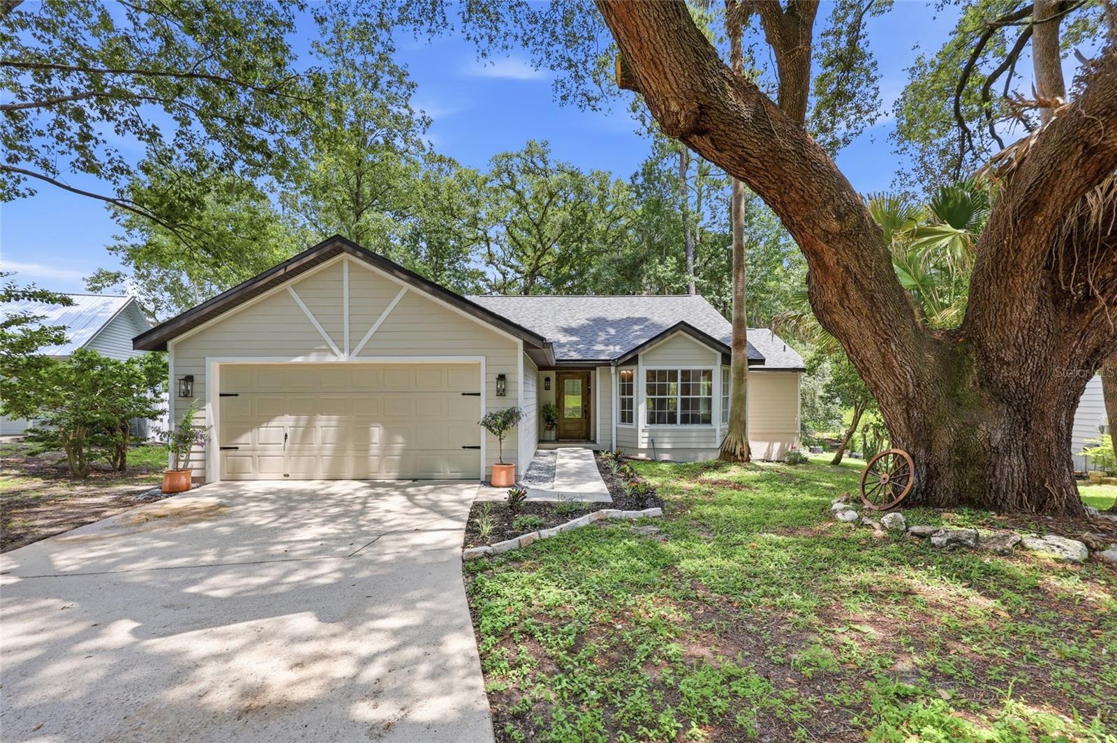 Extensively renovated with exceptional attention to detail, this stunning 3-bed, 2-bath home has been transformed inside and out in the sought-after Northridge community, where shaded streets, a neighborhood pool, and inviting recreational spaces support an easy Florida lifestyle! Every major system and surface has been updated, including Hardie board siding, a 2023 roof, new AC, and a new hot water heater, creating the feel of a truly move-in-ready home. Inside, a vaulted ceiling with a rich dark wood beam sets the tone for the main living space, highlighted by a custom slatted wood feature wall and illuminated floating shelves that serve as a striking focal point. Luxury vinyl plank flooring runs throughout, tying the home together with a warm, modern finish. The kitchen is filled with natural light and features butcher block countertops, high-end appliances, crisp white cabinetry, and a charming breakfast nook framed by bay windows where light shifts beautifully throughout the day. French doors extend the living space outdoors to a newly built back deck, creating an effortless indoor-outdoor connection ideal for everyday living and entertaining. Nearby, a fireplace adds character to the dining area, framed by glass on either side that draws in even more sunlight. The space is currently used for formal meals, though it also offers the flexibility to serve as a comfortable secondary gathering space if desired. From the central hub, the home transitions into a split floor plan that offers added privacy, with the primary suite featuring an ensuite with double vanities, a glass-enclosed shower with decorative tile inlays, and a walk-in closet. Down the hall, 2 guest bedrooms, a full bath, and an indoor laundry room are conveniently situated. Throughout the home, every detail reflects a complete renovation from fresh paint to upgraded finishes, modern lighting, dimmer switches and all-new systems working together to create a residence that feels entirely brand new. A 2-car garage with freshly sealed flooring provides a clean, functional extension of the home for parking and storage. The backyard offers a generous outdoor setting with room to relax, garden, or host friends and family. Located in the established community of Northridge, the home is just minutes from the University of Florida, Santa Fe College, UF Health Shands Hospital, and the VA Medical Center, offering exceptional access to major educational and healthcare destinations. Devil’s Millhopper Geological State Park is also nearby, along with Cofrin Nature Park and Split Rock Conservation Area, providing trails and natural green space for outdoor enjoyment. Shopping, dining, and everyday conveniences are close by at Magnolia Parke, The Oaks Mall, and Butler Plaza. Some properties simply have to be seen in person to appreciate. Schedule your tour today and see how effortlessly this one feels like home from the very first moment!