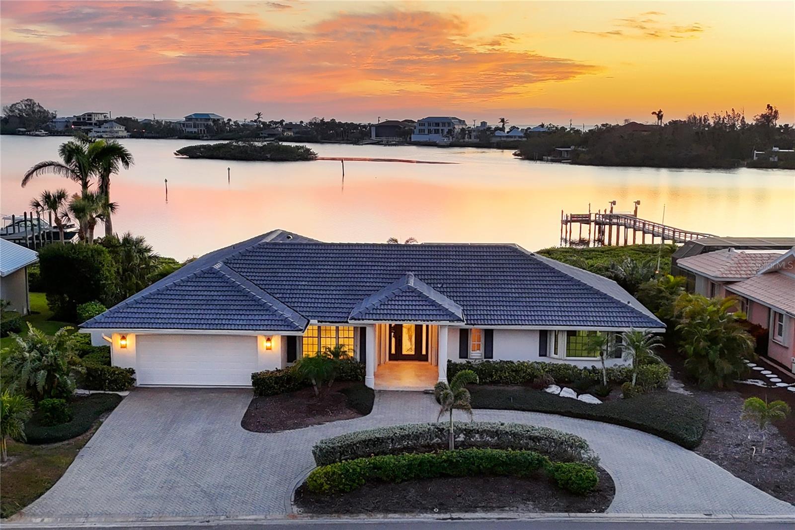 One or more photo(s) has been virtually staged. Considered one of the finest community-owned marinas on the west coast of Florida, Southbay Yacht & Racquet Club features a seven-acre, deep-water boat basin that will accommodate kayaks, jet skis, sailboats, powerboats, catamarans and yachts up to 55 feet in length. With a 6-foot depth at mean low tide, the marina can accommodate 175 boats owned by its residents. In Southbay, the HOA fees are only $612 per quarter, and it's so affordable to keep your boat in a slip, that includes water and electric. With Sarasota Bay in the backyard and the marina within walking distance of your front yard, this property is one of only 17 direct waterfront lots in the subdivision. And the property will allow for a new boat dock and lift to be installed. Inside this renovated home you’ll find three bedrooms, three full baths, a spacious living and family room, along with a heated pool and spa. Plus, there’s a large brick paved sundeck with dramatic views across Little Sarasota Bay and Casey Key. Although the residence has been updated and is move-in ready, you may also consider renovating the home and adding a second floor or building an entirely new home on the half-acre waterfront lot. Southbay Yacht & Racquet Club features a newly renovated clubhouse that overlooks the marina. Inside, there’s a 99-person ballroom with catering kitchen and dance floor, community room with kitchen, piano and entertainment area, a fitness room with aerobic and strength training equipment, a card room, library and meeting room. The community also has a geothermal heated pool, a youth pool, covered outdoor patios with furniture, three tennis courts, four pickleball courts, a bocce ball court, two shuffleboard courts, basketball court, kayak storage area, a waterfront park, 20 acres of common ground and three miles of winding paved walking trails. The development is golf-cart friendly and the community hosts weekly, monthly and multiple annual events, plus there’s even a Power and Sail Club. You’ll love living in this waterfront home and this special community where there’s something for everyone.
