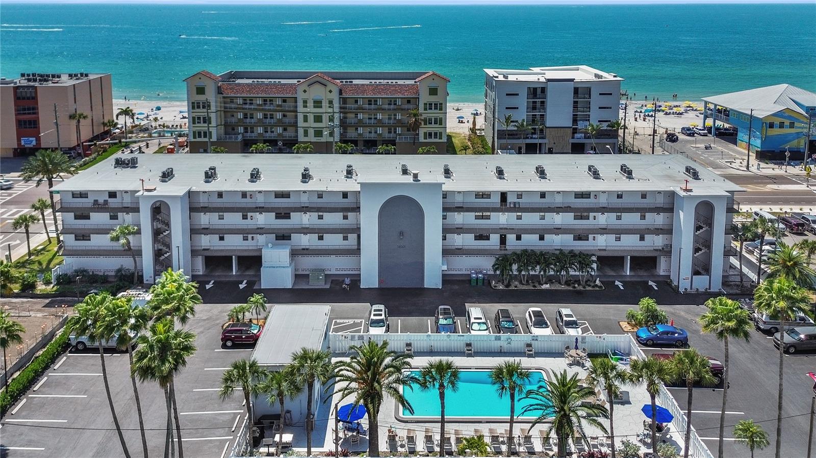 LIVE WHERE YOU VACATION! Experience coastal living at its finest in this Madeira Beach condo offering partial GULF VIEWS and exceptional flexibility for both personal use and SHORT TERM RENTAL INCOME, with no minimum nights required. This fully furnished 1-bedroom, 1.5-bath unit is ideally located near the elevator for easy access and features an open-concept layout filled with natural light, complemented by wood-look laminate flooring throughout. The kitchen includes a closet pantry and breakfast bar, perfect for casual dining or entertaining. The primary suite offers a large walk-in closet and a beautifully updated en-suite bathroom with a tiled walk-in shower and glass enclosure. An IN-UNIT LAUNDRY adds everyday convenience. Enjoy the amenities just steps from your door, including a community pool and BBQ area. BEACH ACCESS is directly across the street at Caddy's, making it effortless to enjoy the sand and Gulf waters. Relax on your private balcony and take in breathtaking sunset views over the Gulf of Mexico. This MAINTENANCE FREE community includes water, sewer, trash, cable, internet, building insurance, and pest control in the monthly fee. Additional highlights include a rare GARAGE SPACE—one of only 15 in the building—along with an extra storage closet. CONVENIENTLY LOCATED, just a short trolley ride to dining, shopping, and John’s Pass, with easy access to both Tampa International and St. Pete-Clearwater airports.