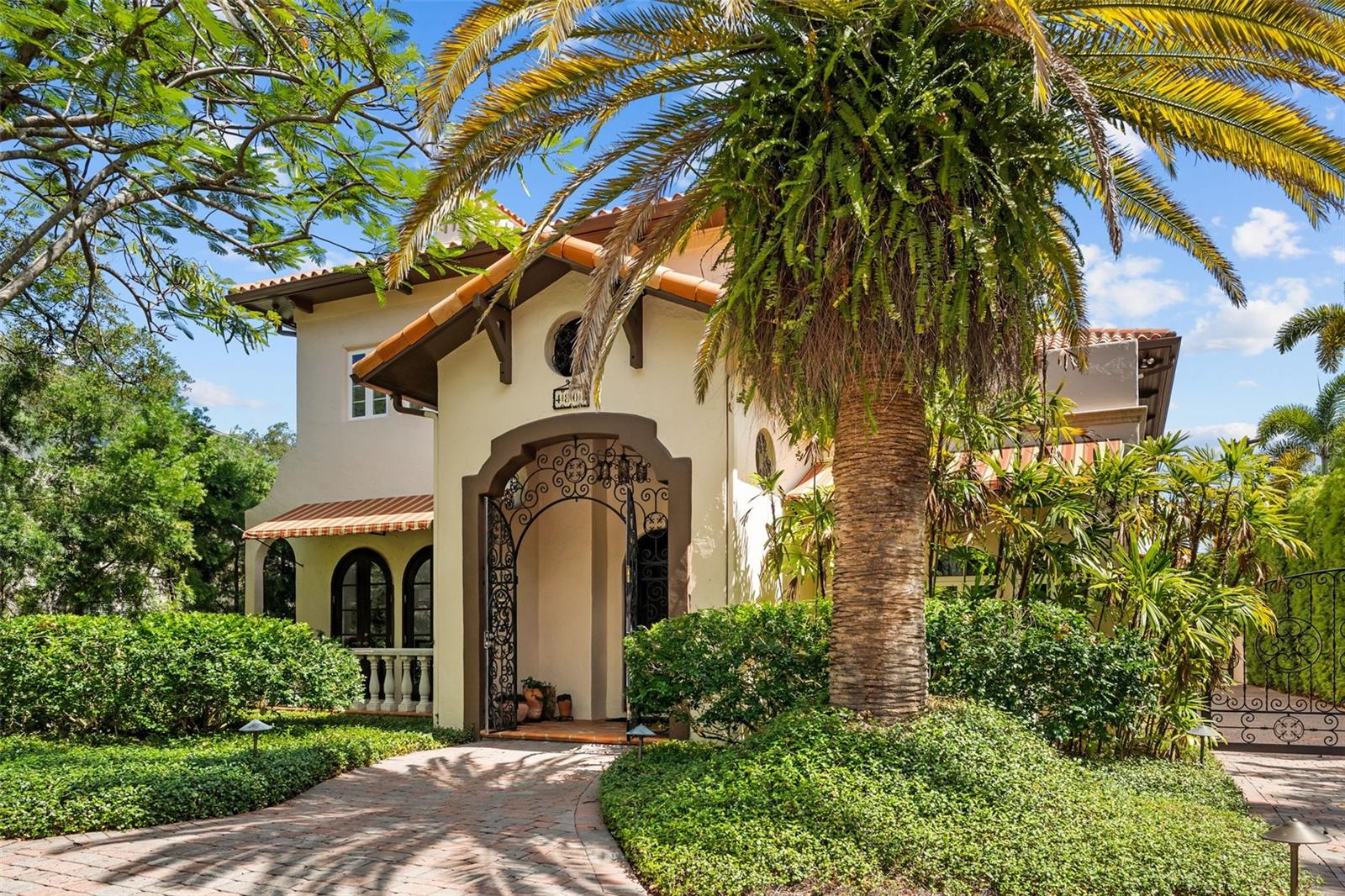 More than a home, this is a private Mediterranean estate that captures the romance of a European summer year-round. Resort-style grounds framed by elegant arches, covered patio, and private balconies overlook a beautifully designed pool and spa surrounded by lush landscaping, terracotta accents, and exceptional privacy. Meandering pathways lead to a tranquil koi pond and a charming garden shed, creating a setting designed for relaxation, al fresco entertaining, and peaceful moments in nature.

A wrought-iron gate and a tile-accented entry vestibule introduce the home's timeless architectural character, where an grand entry door opens to a dramatic two-story living room. Soaring ceilings, arched Honduran Mahogany patio doors, an ornate stone fireplace, and a sweeping staircase adorned with wrought iron and handcrafted tile showcase the exceptional craftsmanship and old-world charm found throughout the residence.  It is residences like this one where character, artistry, and enduring quality took precedence over trends.

Designed for both grand entertaining and everyday living, the home offers a dedicated bar, intimate lounge, and wine cellar, creating inviting spaces to gather with family and friends. The thoughtfully designed floor plan creates a natural flow between the dining room, spacious kitchen, and family room, while French doors and garden views reinforce the seamless connection to the European-inspired outdoors.

Upstairs, four generously sized bedrooms are arranged along a gallery hallway with balcony access.  Completing the estate is a gated driveway and a detached three-car garage with an upper-level bonus room offering endless possibilities as a home office, studio, media room or private fitness space.

Situated in the heart of Beach Park, one of South Tampa's most sought-after neighborhoods, residents enjoy oak-lined streets, distinguished residences, and convenient access to Tampa International Airport, premier shopping, dining, and top-rated schools.