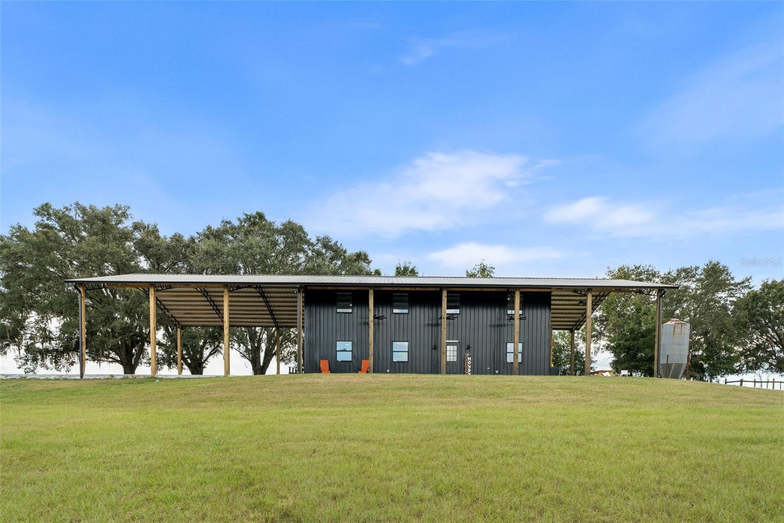 Welcome to one of the most unique settings you will find in this area. Set on a hilltop and spanning 19.34 acres, this property offers a level of privacy, elevation, and views that are hard to come by in Marion County. From the moment you arrive, you can feel the difference, wide open pasture, expansive views, and a quiet that makes you want to slow down and stay awhile. Need more land? ADJACENT 40 ACRES can be sold with this property. 

Located approximately 20 to 25 minutes from the World Equestrian Center, as well as close to Williston and nearby trail systems, this property offers a rare opportunity for someone looking for space, flexibility, and the ability to create something of their own in a prime equestrian area.

The land is already set up with perimeter and cross fencing, a private pond, and a 40x60 pole barn with a 20x60 lean to, providing a strong foundation for horses, livestock, or equipment.

There is a newly constructed structure on the property featuring 3 bedrooms, 2 bathrooms, a loft space, and approximately 3800 square feet under roof, offering flexible use depending on your needs.

Inside, the space has a modern industrial feel with vaulted ceilings, exposed steel trusses, and an open layout filled with natural light, giving it a character that stands apart from more traditional properties.

Whether you are looking to bring your horses, start a farm, or invest in acreage with long term potential, this property offers space, setting, and opportunity in a location that continues to grow in demand.