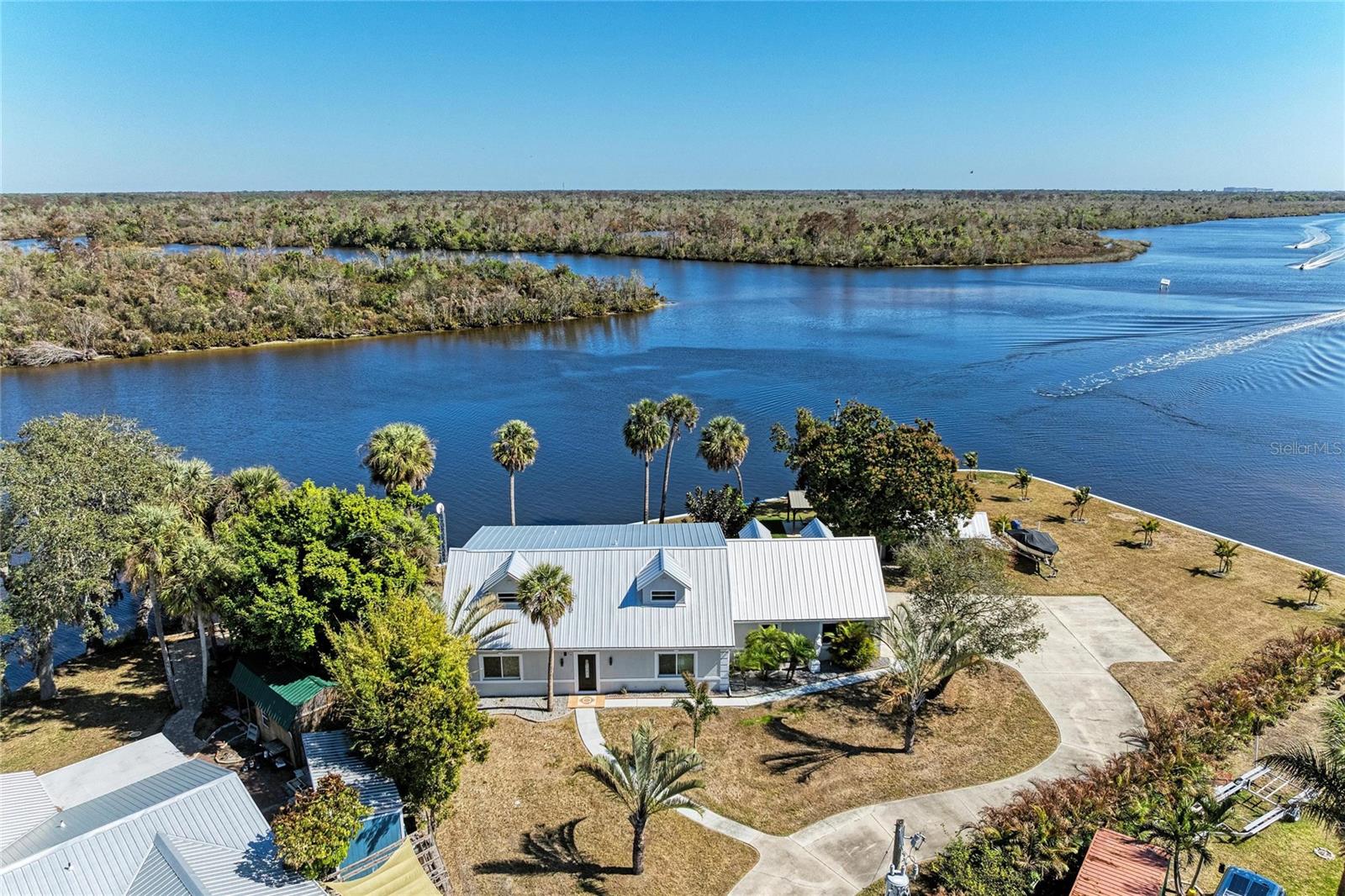 Positioned along approximately 300 feet of Peace River frontage, this turn-key waterfront property offers rare shoreline, expansive views, and exceptional boating access. From your backyard, enjoy world-class freshwater fishing in the Peace River — known for bass, tarpon, snook, and seasonal runs — or cruise downstream with direct access to Charlotte Harbor and the Gulf of America for endless boating adventures. Whether you’re heading out for a sunset cruise, waterfront dining by boat, or offshore fishing, this location delivers true Southwest Florida lifestyle living. Thoughtfully updated and offered fully furnished, the home is move-in ready. Interior improvements include a beautifully renovated kitchen with granite countertops, three fully updated bathrooms, fresh interior paint, tile in the garage, new windows and sliders, newer water system, and a durable metal roof providing long-term peace of mind. Dual Zone Air conditioning with two units provides comfort on both levels. Every detail has been considered to create a comfortable, low-maintenance waterfront retreat. Situated on an expansive .75-acre homesite, the property provides exceptional outdoor space rarely found on riverfront parcels. The depth and width of the lot create endless opportunity — plenty of room to design a custom pool, outdoor kitchen, guest house, additional entertaining areas, or expanded dockage while still preserving privacy and lush green space. The scale of the property allows you to truly maximize the waterfront setting. With the home’s prime positioning along this wide stretch of river, you’ll experience breathtaking sunrises over the water and unwind with equally stunning sunsets across the open sky — something uniquely possible due to the generous lot size and open river exposure. It is a rare combination of frontage, acreage, and panoramic views. Beyond the water, the convenience is exceptional. Located just minutes from historic downtown Punta Gorda, with easy access to I-75 and Punta Gorda Airport, travel — whether by boat, car, or air — is seamless. This property blends privacy and space with connectivity, making it ideal for full-time living, a seasonal escape, or a high-demand waterfront investment opportunity. A true lifestyle property offering boating freedom, fishing at your doorstep, room to expand, and the tranquility that only wide river frontage can provide.