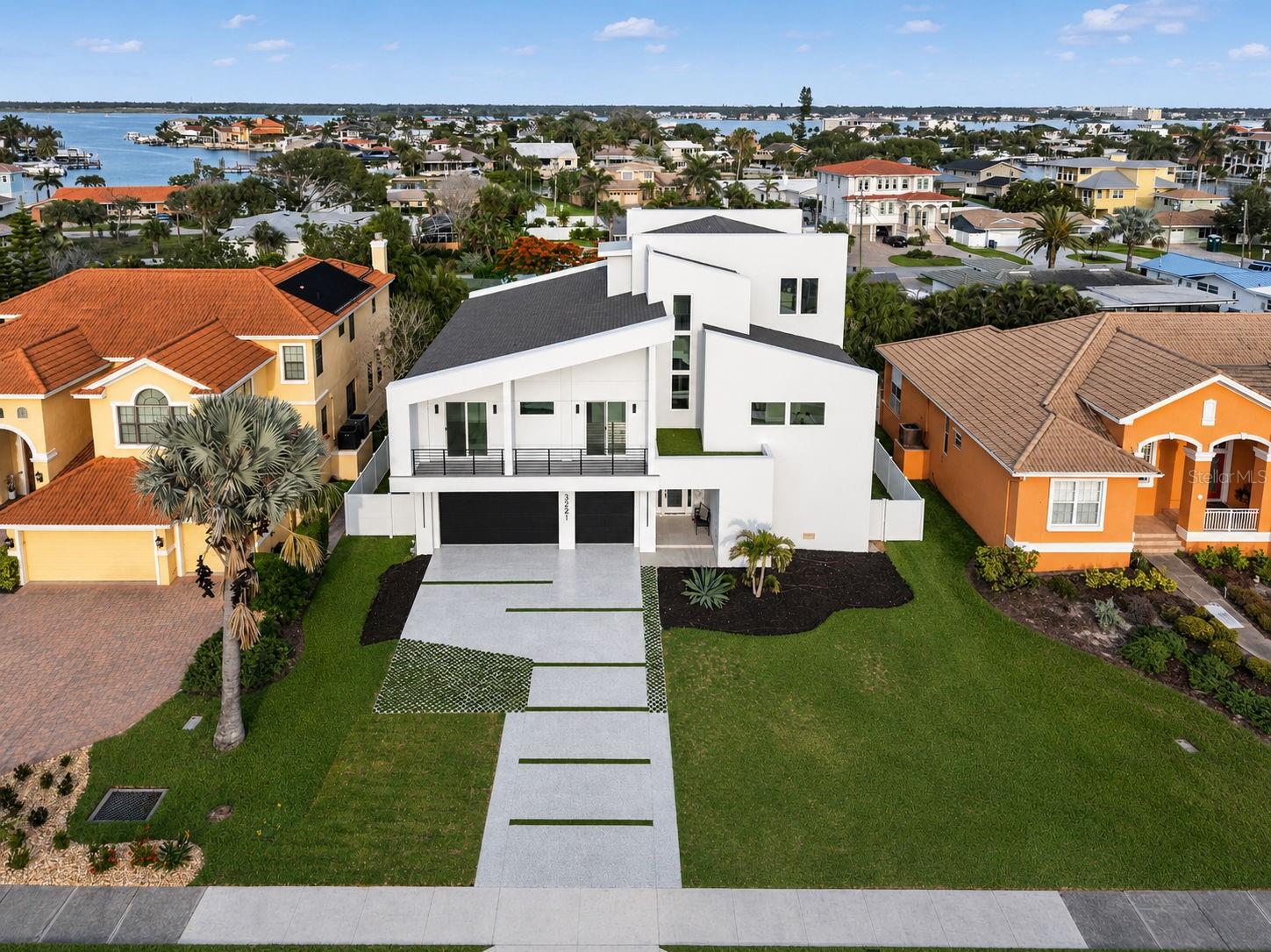 A RARE OPPORTUNITY TO OWN A BRAND NEW LUXURY COASTAL RESIDENCE JUST STEPS FROM THE SANDS OF BELLEAIR BEACH. Welcome to 3221 Gulf Blvd, a newly constructed masterpiece thoughtfully designed for elevated waterfront living, effortless entertaining, and everyday peace of mind. Never lived in and built to impress, this exceptional 4 bedroom, 4.5 bathroom residence offers just under 4,000 square feet of light filled living space with a private elevator, expansive open concept design, and garage space for 5+ vehicles.

From the moment you enter, the home showcases a clean coastal aesthetic with soaring ceilings, abundant natural light, and carefully curated finishes that blend sophistication with comfort. The grand chef’s kitchen serves as the centerpiece of the home featuring high end appliances, custom cabinetry, oversized entertaining island, and an open flow into the spacious living and dining areas perfect for hosting guests or enjoying quiet evenings at home.

Designed with both luxury and longevity in mind, the main living level is constructed at approximately 19 feet above elevation offering enhanced security and confidence for primary homeowners and seasonal residents alike. Hurricane impact rated windows, doors, and openings provide additional durability and protection without compromising style.

Each bedroom offers privacy and comfort with ensuite style accommodations while the primary suite delivers a true retreat with generous proportions and refined finishes. Multiple outdoor living spaces create the perfect setting to enjoy coastal breezes while enjoying partial views of the Gulf of Mexico and Intracoastal waters.

Located within walking distance to the Gulf of Mexico shoreline, this residence places you moments from sugar sand beaches while still offering convenient access to dining, shopping, marinas, golf courses, and nearby Clearwater Beach. Whether searching for a luxury primary residence, second home, or secure coastal getaway, 3221 Gulf Blvd delivers modern construction, premium elevation, water views, and timeless appeal in one of Tampa Bay’s most desirable beach communities. This is Florida luxury living done right.