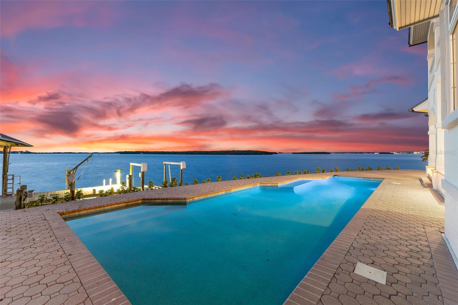 One or more photo(s) has been virtually staged. Ideally situated on a prime lot that boasts unobstructed panoramic water views. This extraordinary estate offers a secluded cul-de-sac location and an expansive 166 feet of BRAND NEW SEAWALL, providing unmatched privacy and a vast sense of space.

Originally built in 1995, this newly available estate, crafted by the acclaimed 'Monogram' builders, stands as a testament to luxury and meticulous design. The residence includes six spacious bedrooms, four and a half lavish bathrooms, and an oversized two-car garage. Recently enhanced with a brand NEW METAL ROOF, NEW WOOD FLOORING throughout, and a fresh modern color scheme, the home exudes coastal elegance and timeless charm.

Your private backyard retreat offers breathtaking views of St. Joseph Sound, the prestigious Carlouel Yacht Club, and Moonshine Island. The private dock is a boater’s dream, complete with a covered 15,000 lb BOAT LIFT, a 6,000 lb BOAT LIFT, a DEEP-WATER SLIP, and a deck area fully equipped with water and electrical hookups.

Outdoor living is perfected with a covered lanai and a private, heated Pebble Tec swimming pool, ideal for both relaxation and entertainment. As you step inside, you are immediately captivated by the expansive water views that greet you and extend through the family and living rooms, enhancing the home’s serene ambiance.

The luxurious primary suite features 10-foot ceilings and a private balcony that offers stunning vistas and a tranquil escape. The primary bathroom is a spa-like haven with a steam shower, a garden tub, and a spacious walk-in closet designed for ample storage.

Island Estates, nestled along the Gulf Coast, provides a serene and luxurious lifestyle with a variety of amenities including charming shops, convenient banks, vibrant bars, and exquisite restaurants. This community offers a unique blend of tranquility and vibrancy, allowing residents to enjoy the best of both worlds. 

Just a short bike ride or walk away, Clearwater Beach is consistently ranked as the top beach in the United States. Known for its soft, white sand and crystal-clear waters, Clearwater Beach is perfect for sunbathing, swimming, and a variety of water sports. The area is also home to Pier 60, where you can enjoy nightly sunset celebrations, live entertainment, and local artisans.

Whether you seek relaxation under the sun or thrilling water activities, Island Estates and Clearwater Beach offer an irresistible blend of luxury and leisure. This stunning waterfront estate is not just a home; it's a lifestyle, providing you with the perfect sanctuary to enjoy the best that Florida's Gulf Coast has to offer.