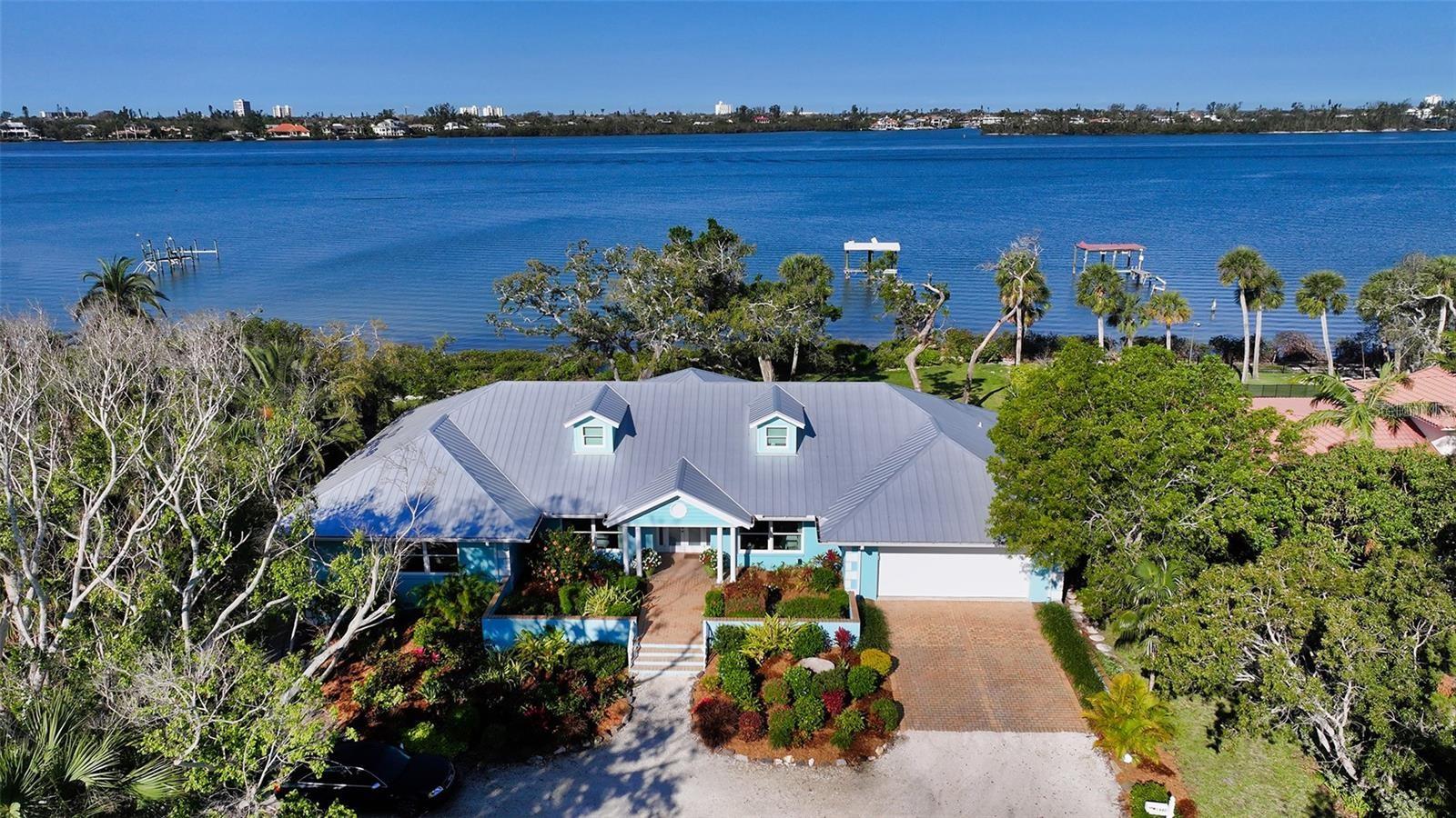 Located on approximately 200 feet of open Bay frontage in one of Sarasota's most prestigious neighborhoods, this remarkable property enjoys a postcard-worthy setting on more than an acre of beautifully landscaped grounds near The Field Club. A 150+/- foot private dock, expansive lawn, and breathtaking panoramic views create one of Sarasota's truly exceptional waterfront offerings. The residence is in outstanding, like-new condition, with all major systems and components replaced in 2017. Thoughtfully designed with an open floor plan, the home offers three private en-suite bedrooms and a relaxed island-inspired aesthetic complemented by textured wall finishes, tray ceilings, crown moldings, custom built-ins, designer lighting, and fine finishes throughout. The spacious great room is ideal for entertaining, while the well-appointed kitchen is perfectly positioned between a charming breakfast room and formal dining area. Additional features include an oversized laundry room, generous air-conditioned attic storage, an attached two-car garage, and an air-conditioned workshop that could also serve as a third garage bay. For many, however, the true rarity lies in the land itself. With approximately 200 feet of open Bay frontage, more than an acre of prime waterfront, and surrounded by Sarasota's most significant estates, this is the kind of homesite that rarely becomes available. While the existing residence can be enjoyed immediately for years to come, the property also presents an extraordinary opportunity to create a world-class waterfront estate that fully realizes the potential of this iconic setting. Quite simply, the value of this offering extends well beyond the home—it is an opportunity to own one of Sarasota's premier Bayfront properties. Offered at a compelling value among the area's most prestigious waterfront estates, this is a rare chance to secure an irreplaceable piece of Sarasota's shoreline for today and for generations to come.
