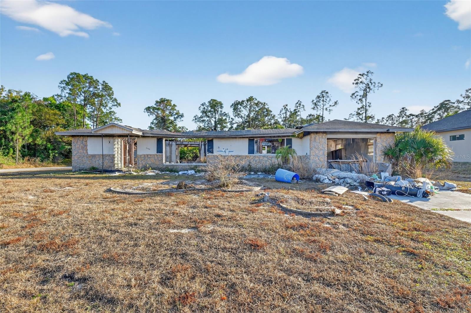 Investor Special in Lehigh Acres! Fire-damaged home situated on a spacious 0.25-acre lot, offering endless potential for renovation or brand-new construction. This property is ideal for investors, builders, or buyers looking to create a custom home. Plenty of room to design, rebuild, or reimagine. Conveniently located with easy access to main roads, shopping, and schools. Bring your vision and unlock the possibilities this property has to offer.