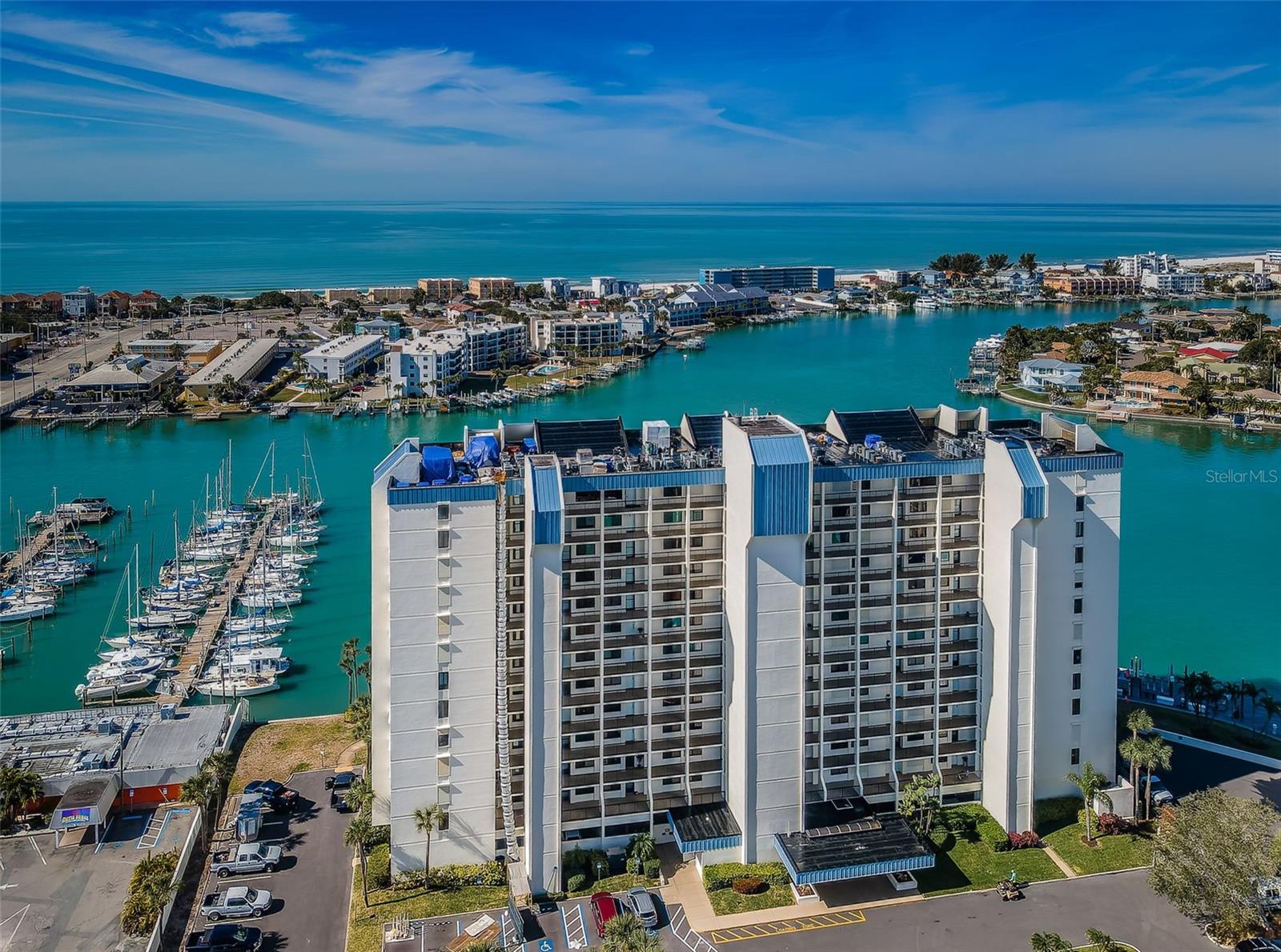 This is one condo you will rarely find. You have fabulous waterviews of the intracoastal and the Gulf as well as gorgeous sunsets changing year-round. You also enjoy marina views from the comfort of your covered screened balcony accessible not only from the living area, but from your primary bedroom. Nothing was spared over the past few years as it went through a major renewal and is ready for you to enjoy. All the tile and carpet was removed and the entire flooring was professionally installed with high quality, neutral Shaw luxury vinyl. The blinds were replaced throughout with Levelor blinds. All the dated wall mirrors were removed, all the doorknobs replaced with modern brushed nickel, and the entire condo was painted. The spacious kitchen has an area by the large window that could be an eat-in place or used as it is now for entertainment. The sleek solid wood cabinets, granite countertops and center island highlight this kitchen along with the stainless-steel appliances (refrigerator, dishwasher, microwave, 2024 range and 2025 disposal). The open layout seamlessly connects the living and dining areas as it moves your eye to the balcony and the beautiful view. The sliding doors span the width of the living room and have had all the tracks and hardware replaced for smooth opening and closing. The sliding glass doors and windows were rebuilt in 2025. The living room ceiling fan was replaced by a high style fixture for your enjoyment. You will cherish the view from the primary bedroom from its window or step out to the balcony through the private door. This spacious ensuite bedroom also has a large nicely outfitted walk-in closet. Both bathrooms were remodeled and professionally upgraded in 2022 with new mirrors, modern medicine cabinets, and high-quality contemporary shower doors. The primary bathroom also has updated light fixtures and a Bluetooth-enabled fan. There is even a washer and dryer for you to enjoy. The hurricane shutters on the balcony were refurbished in 2024 (which qualify for an insurance deduction), the entry storm door has an upgraded retractable screen and a coded entry lock, new air-conditioner in 2019. The recently completed $2,000,000+ major building restoration project involved stucco repairs, waterproofing, painting, re-constructed walkways and balconies, and new railings. The new sea wall was completed in 2026, new AC 2019, and new roof 2020. The walkway entrance to the building was refinished in a complementary Gemstone product to match the new balconies, walkways, and sidewalks where the remodeled lobby welcomes you home. Perhaps the best of all is living in this gated parklike property directly on Boca Ciega Bay. Enjoy 24-hour security and all the amenities and activities to explore. There’s a waterfront clubhouse where you can enjoy social events, a state-of the art fitness center, sauna in the changing rooms, bar-b-que grills. The heated pool and spa area has a large deck with a Jacuzzi, and gazebo to relax and enjoy. You can play tennis and pickleball on the Har-Tru courts or enjoy the shuffleboard courts. The marina has community docks and boat slips available for lease or purchase by owners. There’s always something to see on the water whether it’s the holiday boat parade passing by, or the dolphins playing. Short drive to downtown St. Petersburg, even Tampa and the airport, if you want to venture out. Paradise at its best!
