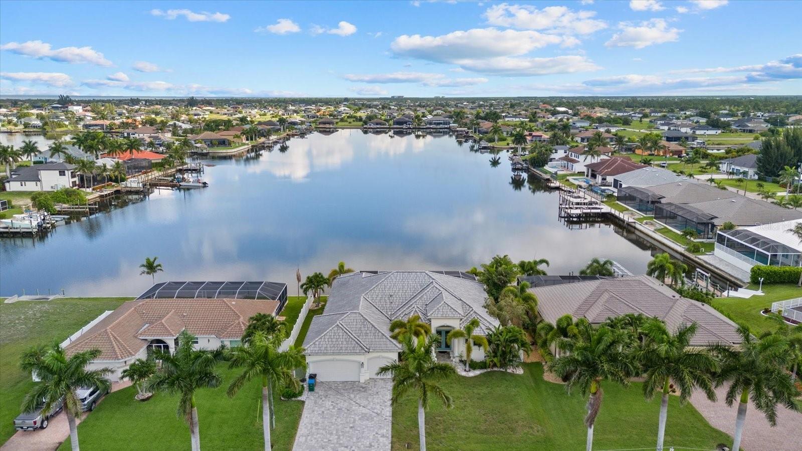 Gulf access, unobstructed lake views down the entire length of the waterway, and zero bridges to open water. SOLD TURNKEY. Welcome to 4227 NW 28th Street, a stunning 2018-built waterfront retreat in Northwest Cape Coral offering the kind of lifestyle most only dream about.
Situated on an oversized lot with 80 feet of saltwater canal frontage and direct lake views over Lupine Lake, this 3-bedroom PLUS DEN, 3-bathroom home delivers 2,526 square feet of refined living space with a 3-car oversized garage. Block construction, tile roof, impact windows and doors, and a paver driveway give this home the curb appeal and durability that sets it apart from anything nearby.
Step inside to soaring coffered and back-lit LED tray ceilings, crown molding, plantation shutters, solid wood cabinetry, and large format tile throughout. The open concept kitchen is the heart of the home featuring sealed horned granite countertops, a double built-in oven, Monogram cooktop and range hood, wine refrigerator, a large center island, a wet bar, and a dinning area with an additional set of sliders out to the pool. Picture window screening frames completely unobstructed, expansive water views from virtually every main living space, bringing the lake and canal backdrop into the home in a way that never gets old.
The primary suite is its own private retreat with pocker sliding doors leading directly to the spa, dual walk-in closets, a large soaking tub, and an oversized stone shower with dual shower heads. The split bedroom floor plan keeps guests comfortable and separate, while the den flex space works perfectly as a home office or fourth sleeping area. 
Outside, the screened lanai with picture window screening creates a resort-style setting around the heated saltwater pool and integrated heated spa. The outdoor kitchen is fully equipped for entertaining. The 3rd bathroom also acts as a pool bathroom with access to the lanai for ease of access. A vinyl privacy fence encloses the yard, mature landscaping and rock beds frame the property beautifully, and a lawn irrigation system keeps everything looking sharp year round. The large 3 car garage is also finished with an epoxy coating.
The entire home is served by a whole house reverse osmosis water system, delivering purified water to every tap and appliance throughout the property.
For boaters, this property is exceptional. The concrete seawall was built in 2018, there are no fixed bridges to the Gulf, and Matlacha and Pine Island are just a short ride away. The home has a proven track record as a high performing short term rental with no HOA restrictions limiting your options.
No CDD. No HOA. Turnkey. Gulf access. This one checks every box.