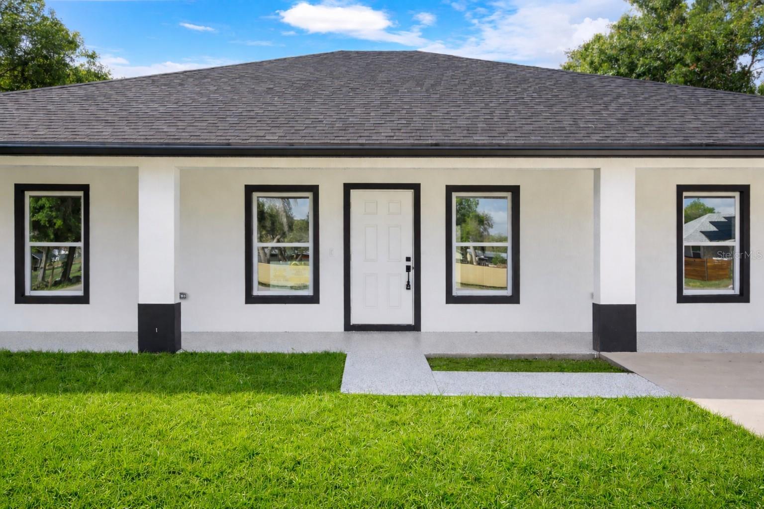 Beautiful brand new 3-bedroom, 2 bath CBS home in Okeechobee featuring 10-foot ceilings and a spacious covered front porch perfect for morning coffee and sunset views. The kitchen offers tall wood cabinets, quartz countertops, and stainless-steel appliances. Interior highlights include tile floors throughout, tiled showers, and sleek black fixtures. Enjoy backyard views from the covered rear porch. Impact windows, central A/C, custom closets and doors complete this move-in ready property. Plenty of room for your boat, RV, or toys.