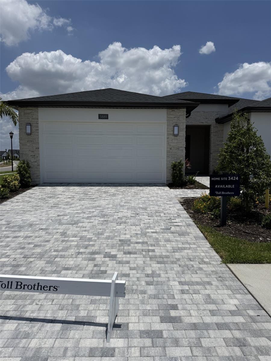 The Dunlin is a Toll Brothers Villa featuring the perfect blend of luxury, comfort, and effortless Florida living. This beautifully designed single-story home welcomes you with a charming front porch and an inviting foyer that leads into an open, light-filled living space. A versatile flex room provides endless possibilities for a home office, hobby room, or cozy den.
The spacious great room, highlighted by an elegant tray ceiling, flows seamlessly into the casual dining area and gourmet kitchen, creating the perfect setting for both everyday living and unforgettable gatherings. The thoughtfully designed L-shaped kitchen features a large center island with breakfast bar seating, abundant cabinetry, generous counter space, and a convenient pantry, making meal preparation both functional and enjoyable.
Step through expansive sliding glass doors to the covered lanai, where you can relax with your morning coffee, entertain friends under the Florida sunshine, or unwind while enjoying peaceful outdoor living.
The private primary suite serves as a tranquil retreat, complete with an elegant tray ceiling, an oversized walk-in closet, and a spa-inspired bath featuring dual vanities, a luxurious walk-in shower, and a private water closet. A welcoming secondary bedroom is perfectly positioned near a full bath, providing comfort and privacy for guests or family members.
Additional highlights include a centrally located laundry room, an everyday entry, abundant storage throughout, and carefully designed spaces that combine timeless elegance with everyday convenience. Imagine yourself coming home to refined craftsmanship, bright open spaces, and the exceptional lifestyle that only a Toll Brothers Villa can provide.