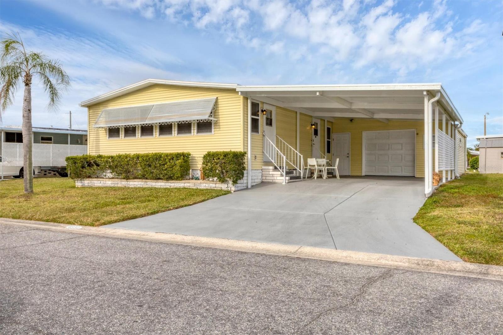 Welcome to Tidevue Estates, a desirable land-owned 55+ community offering comfort, convenience, and an open floor plan. This home features a NEW MEMBRANE ROOF in 2025. Stylish vinyl flooring in the kitchen and dining room. The spacious kitchen has a large island with breakfast counter, perfect for casual dining and entertaining. The living room offers vaulted ceilings, creating a light and airy feel, with an alcove off the living area ideal for a home office or den. The primary bedroom measures 14x11 and includes an en-suite bathroom with a walk-in tub which also allows for a sit down shower. Additional highlights include a one-car attached garage with easy-access ramp into the home, plus extra space for a workshop and storage. The oversized carport accommodates two vehicles and offers ample room to create an outdoor living area—perfect for relaxing or entertaining guests.  Low HOA of only $600 annually. Pets are not permitted. Plenty of activities to keep you busy in this community. Take a water aerobics class in the solar-heated community pool or work on your tan. The community library has free WI-FI connection. Updated fitness center. Meet friends and make new ones for a game of indoor pickleball, bocce ball, or shuffleboard. Join the Golf League. Take a bike or golf cart ride to Veteran's Park to watch the wildlife and sunset. Ellenton Premium Outlet Mall, restaurants, and medical facilities are just minutes away. Easy access to I-75. Not to mention a short drive to our beautiful Gulf Beaches.