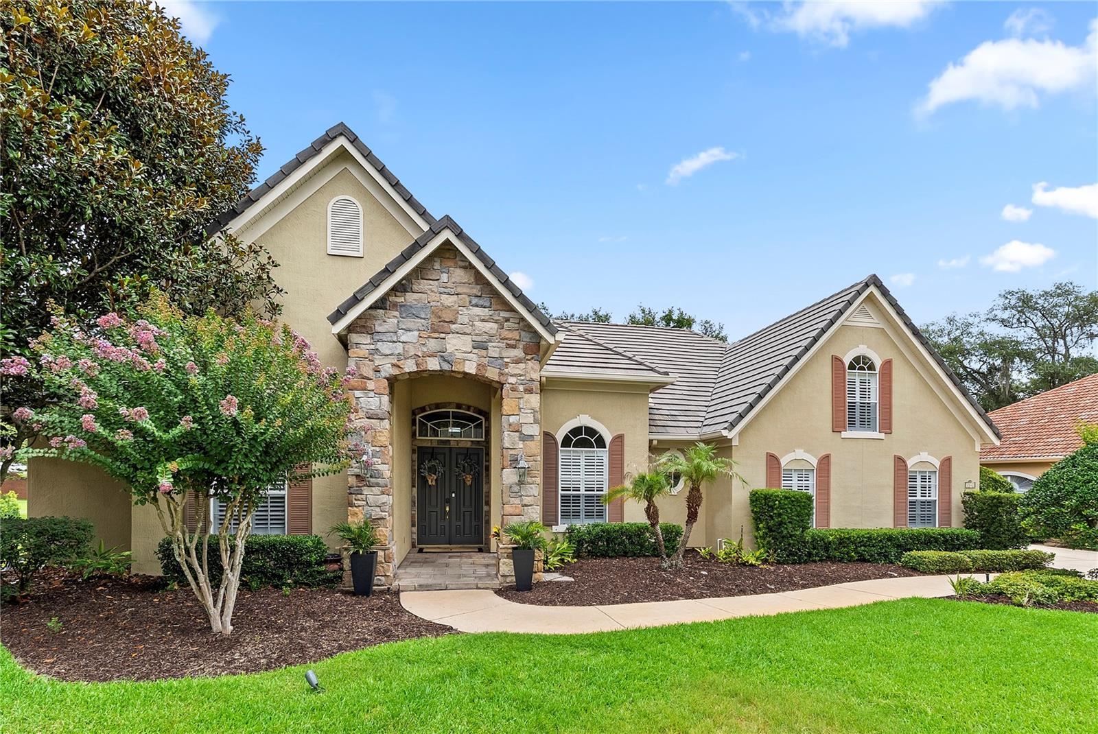 Seller will consider a credit towards roof replacement. Nestled behind the guarded gates of the prestigious Westover golf community, this exceptional custom-built estate blends timeless elegance with modern updates, creating an extraordinary place to call home. Set on a beautifully landscaped corner homesite, the residence makes an immediate impression with its striking stone-accented elevation, manicured grounds, and custom architectural lighting. Designed for both refined entertaining and comfortable everyday living, the thoughtfully crafted floorplan features 4 bedrooms, 4 bathrooms, formal living and dining rooms, a private office, and an expansive family room with soaring ceilings, with all living areas conveniently located on the main level except for a private upstairs guest suite with its own full bath. Rich architectural details including triple crown molding, designer tile flooring, and custom finishes enhance the home’s sophisticated character throughout. At the heart of the residence, the beautifully updated chef’s kitchen showcases new granite countertops, stainless steel appliances, custom 42-inch cabinetry, a designer range hood, center island, and butler’s pantry. The luxurious primary suite serves as a private sanctuary, featuring a romantic two-sided fireplace, spa-inspired bathroom with a dual-head walk-in shower, separate Jacuzzi soaking tub, and an oversized custom walk-in closet. Step outside to your own private resort, where a spectacular pool and spa are complemented by an expansive covered lanai and additional patio space, creating the perfect setting for year-round entertaining and relaxation. Combining privacy, elegance, and an outstanding location within one of Central Florida’s most sought-after golf communities, this remarkable residence offers a rare opportunity to enjoy luxury living at its finest.