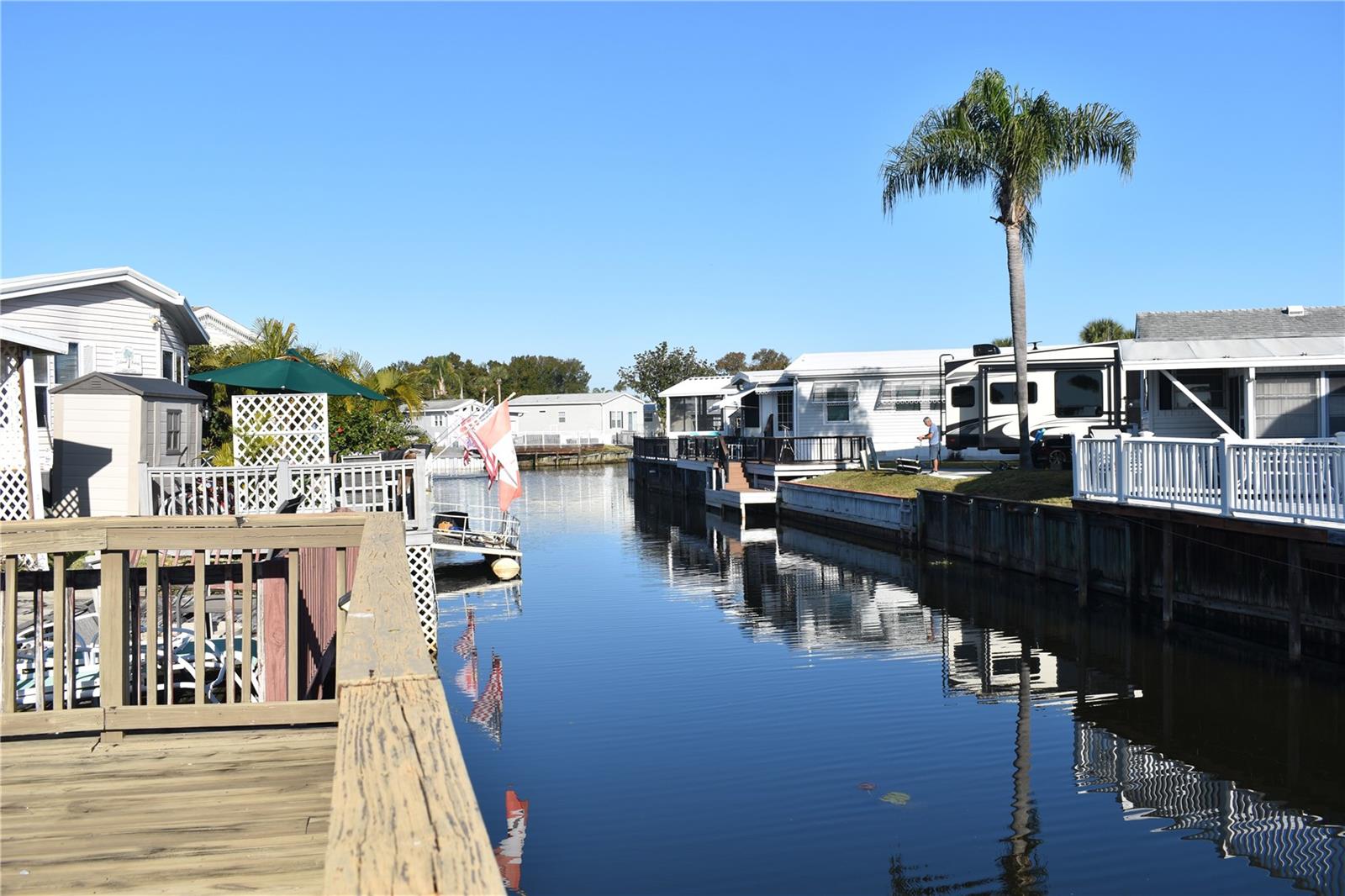 CANAL LOT WITH ACCESS ONTO LAKE DAVENPORT!  Diamond in the rough! Looking for a water-view property at a budget-friendly price? Then read on.  This delightful bedroom home offers a fantastic opportunity for a buyer seeking a blank canvas or a DIY project. The layout includes a separate living room plus a versatile bonus room featuring a walk-in closet and access to the laundry room. Currently used as a second bedroom, the bonus room could easily be transformed into a home office, den, or hobby room. Transom windows in the family room allow for an abundance of natural light, creating a bright and welcoming living space.  Situated on a canal-front lot, the property features a wooden deck with steps leading down to a small dock, offering tranquil water views and great outdoor potential. The home has been priced to reflect the updates and repairs needed, making it an excellent value for the right buyer.  Outdoor Resorts at Orlando is a secure, resident-owned community where homeowners own the land. The affordable quarterly HOA includes basic cable, water, sewer, trash removal, lawn care, a manned security gate, and full access to extensive resort-style amenities. These include a clubhouse, two community pools, tennis and pickleball courts, shuffleboard, mini golf, a nine-hole golf course, and more. The community is located on Lake Davenport with a boat ramp and first-come, first-served boat slips, along with onsite laundry facilities and a dedicated dog park. Ideally situated on US Highway 192, Outdoor Resorts is just minutes from shopping, dining, medical facilities, and a short drive to Disney and Central Florida attractions—perfect for seasonal enjoyment or year-round living.