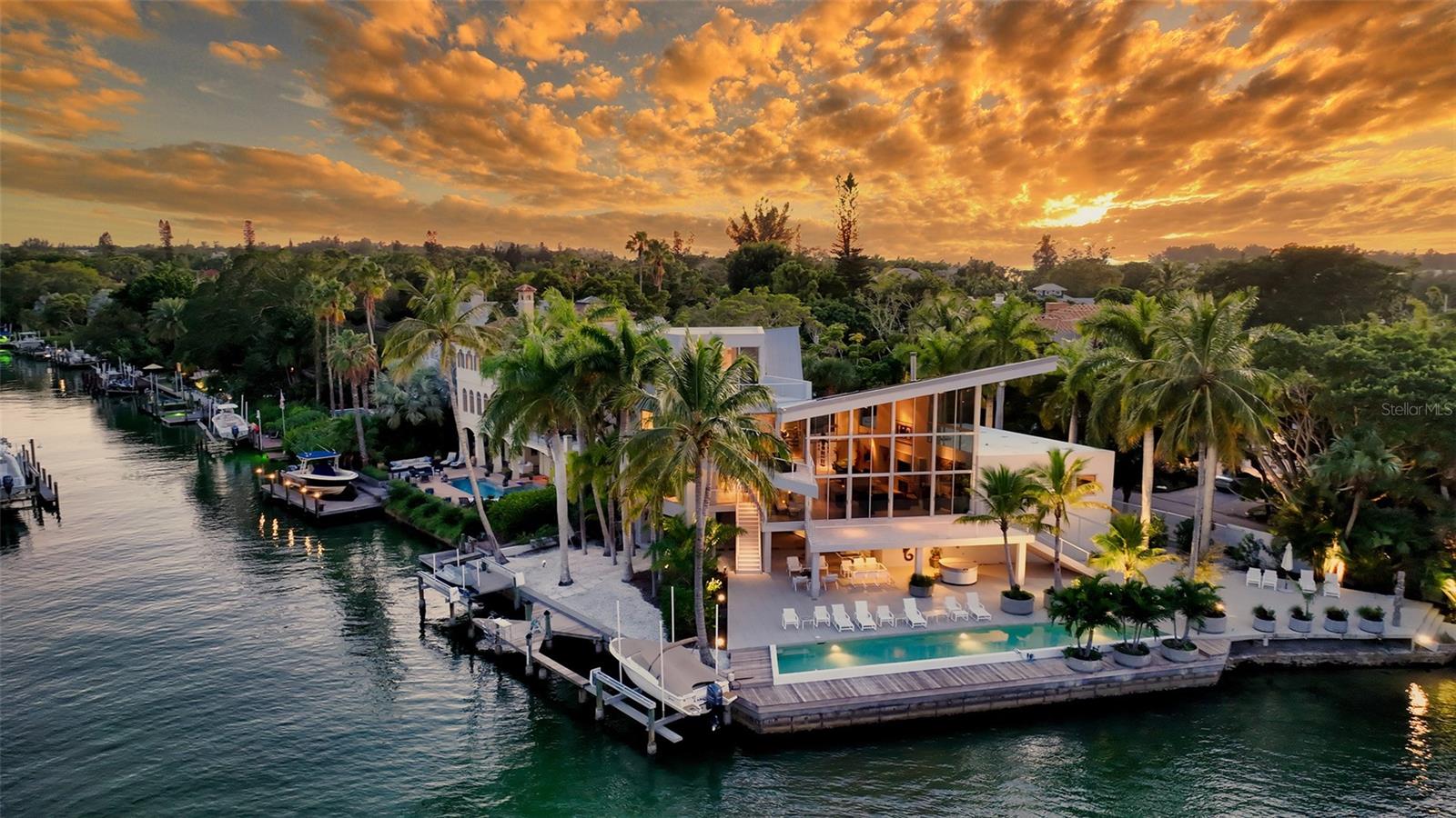This architectural award-winning residence offers big bay and city skyline views that leave one speechless. The stunning Carl Abbott residence was designed to maximize views and to accentuate natural light. The result is one of Sarasota's most exciting residences. The home offers carefree living, glamorous entertaining and the opportunity to be one with the beautiful natural surroundings. The property is walled and gated. An exciting entry courtyard makes an immediate statement about the quiet elegance of this striking residence. The dramatic living area with floating roof opens to terraces from both the north and south. The fireplace provides a nice touch. Travertine floors and abundant walls of glass give the home a wonderful feeling of openness. A granite and maple kitchen was designed by serious cooks with great attention to detail and quality. The owner just added all high-end appliances. The 4th bedroom or office has forever views and fabulous view terrace and is an ideal private retreat. The home features a very private and separate master suite with its own terrace for gulf and city skyline views. Two additional guest suites are located on the 1st level ideal for family living. A media room enhances the main level amenities as well. The entire lower level is garage and loads of storage space. Elevator shaft is in place for ease of addition. Two sides of water frontage make the rare combination of unobstructed views and deep water protected dockage accommodating large boats on Hansen Bayou a reality. There’s a Tiki hut and a beach perfect for the adventurous you might like to swim with the ever-present dolphins. A recently resurfaced 65' lap pool is a gorgeous jewel accentuating the expansive terraces on every level of the home. Custom built by Tom Hensey; the residence is constructed to the highest standards for discerning owners.