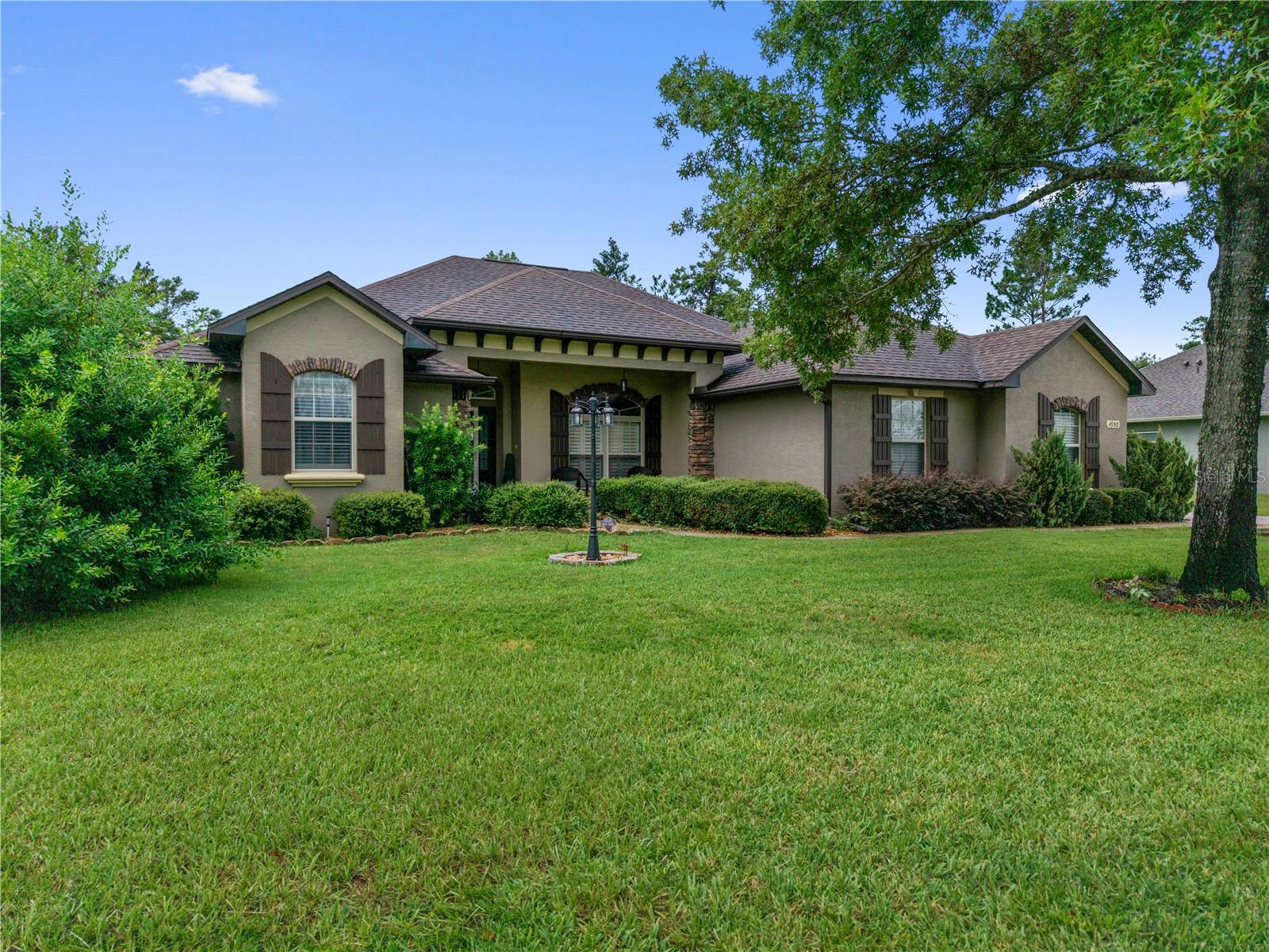 The largest of Marco Polo Village II's original builder custom built model homes loaded with upgrades, this thoughtfully enhanced custom residence offers architectural character, exceptional functionality, and nearly half an acre in one of southwest Ocala's most desirable locations. From the moment you enter, you'll appreciate rich hardwood flooring, rounded drywall corners, crown molding, decorative niches, dramatic architectural ceilings, open floor plan and a beautiful tongue-and-groove wood ceiling in the family room. One of the home's signature features is the fully pocketing sliding glass doors that disappear into the wall, seamlessly connecting the living and family rooms into one expansive entertaining space. The gourmet kitchen features granite countertops, furniture-style cabinetry, Whirlpool stainless steel appliances, dual microwaves, pot filler, pantry, breakfast bar and a built-in coffee and tea station. Just beyond, the spacious laundry room offers abundant cabinetry, utility sink, washer and dryer, plus a second walk-in pantry for exceptional storage. Designed as a true retreat, the split-plan owner's suite features a private lounge with an elegant chandelier—perfect as a home library, office, nursery, or quiet place to begin or end your day. Two custom walk-in closets and a spa-inspired bath with separate vanities, Roman shower, jetted tub, private water closet, and custom reclaimed wood and industrial pipe shelving complete the suite. The guest bedrooms have tray ceilings. Outside, enjoy a pergola-covered patio, dedicated fire pit gathering area, fully fenced backyard, side-entry garage, and a 12' × 24' fully powered workshop. With nearly one-half acre, there's still plenty of room for a future custom pool. Ideally located near the World Equestrian Center and the Florida Trail's 49th Avenue Trailhead, yet just minutes from shopping, dining, medical facilities, and I-75, this beautifully maintained home offers the perfect balance of peaceful living and everyday convenience.