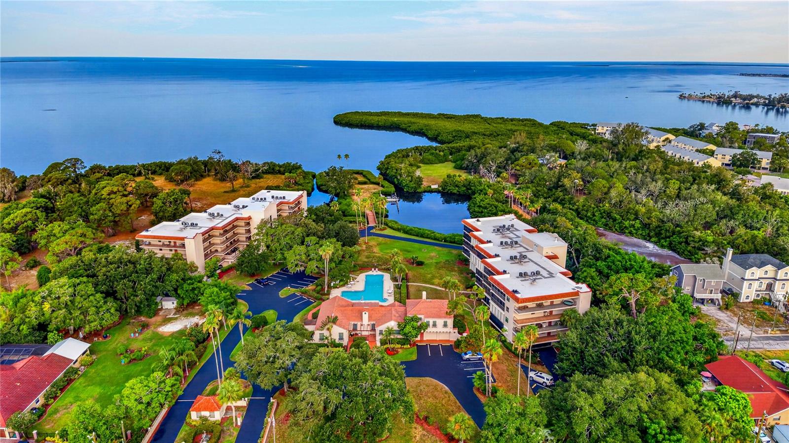 Experience Gulf-front living at its finest in this rarely available waterfront residence located within the exclusive, gated Gulf Front Lagoon community in the heart of Tarpon Springs. Perfectly positioned on beautifully maintained grounds overlooking the Gulf of Mexico, this spacious and beautifully updated second-floor condominium offers approximately 1,490 square feet of living space, plus an expansive enclosed glassed-in lanai for year-round comfort while enjoying breathtaking water views & spectacular year-round sunsets. Views of historic clubhouse, pool, and footbridge that guides the eyes across the lagoon to a secluded island featuring its own private dock perfect for fishing. Beyond the island is the shimmering expanse of St Joseph Sound & the Gulf of Mexico.

Designed for both comfortable everyday living and effortless entertaining, the open-concept floor plan is filled with natural light and showcases sweeping Gulf vistas from the main living areas. The spacious great room features a cozy wood-burning fireplace, dining area, and large sliding glass doors that seamlessly connect the indoors with the waterfront lanai. The updated kitchen is a chef’s delight, boasting custom cabinetry, granite countertops, stainless-steel appliances, new range & microwave, pantry storage, & generous workspace. Additional features include Plantation Shutters throughout, crown molding, fresh paint throughout, & new roof (2025).  

The primary suite serves as a private retreat with direct lanai access, abundant closet space, and a beautifully appointed en-suite bath featuring dual vanities, granite countertops, a large luxury walk-in shower with multiple shower heads, & custom-designed walk-in closet storage. The guest bedroom offers exceptional flexibility with a custom-built queen size Murphy bed complete with dresser, cabinets, desk & ample closet space, with access to en-suite bath featuring a spacious jacuzzi tub & beautiful tile work. With access to private entrance, these accommodations are perfect for family and visitors.

Residents enjoy a true resort-style lifestyle within this boutique 40-unit community. Amenities include a waterfront swimming pool & spa, fitness center & separate saunas for men and women, picnic & grilling areas, bike storage, kayak & paddleboard launch, fishing & boat dock, & a beautifully restored historic clubhouse complete with billiards, library, meeting rooms, kitchen facilities, & social gathering spaces. Private walking paths & charming bridges wind throughout the lushly landscaped grounds, creating a peaceful coastal setting unlike any other.

Additional conveniences include a private elevator, under-building assigned parking, private storage, guest parking, and comprehensive condominium fees that cover cable, internet, water, sewer, exterior maintenance, building insurance, reserves, roofing, and more.

Ideally located just minutes from Fred Howard Park Beach, Sunset Beach, Tarpon Springs Golf Course, Downtown Tarpon Springs, the world-famous Sponge Docks, restaurants, shopping, & easy access to Tampa, St. Petersburg, & Clearwater airports, this exceptional property offers the perfect blend of luxury, privacy, and convenience.

Whether you’re searching for a full-time waterfront residence, a seasonal retreat, or a second home where every day feels like a vacation, this remarkable Gulf-front condominium delivers an unparalleled coastal lifestyle in one of Tarpon Springs’ most desirable communities.