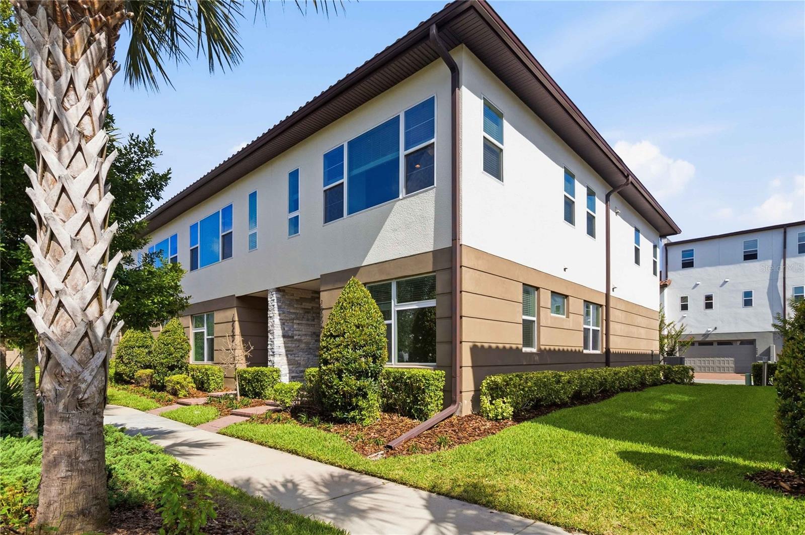 Virtually Staged. Welcome to this Corner Townhome which is Clean and Modern; situated in The Gated Master Planned Golf Community of Eagle Creek in Lake Nona. As you enter the front door from the community park, there are 2 bedrooms and a full bathroom on the first level. A laundry room with full size washer and dryer are included and leads to a 2-car attached garage that faces the back of the unit.
Upstairs there is an Open Concept Floor Plan with living room/dining room combo, and kitchen Island. This Chef-Inspired Kitchen is fully Equipped with glass cooktop, hooded fan, built in microwave and oven and stainless-steel refrigerator. The Kitchen Island seats up to 4 countertop stools. The entire 1st and 2nd flooring is ceramic tile for easy maintenance, and carpet on the stairs. The Master Suite is also upstairs and living room has an oversized window overlooking the view of a park with a lovely view. MUST SEE to Appreciate this Beautiful Townhome and Turn your Dreams into a Realty!