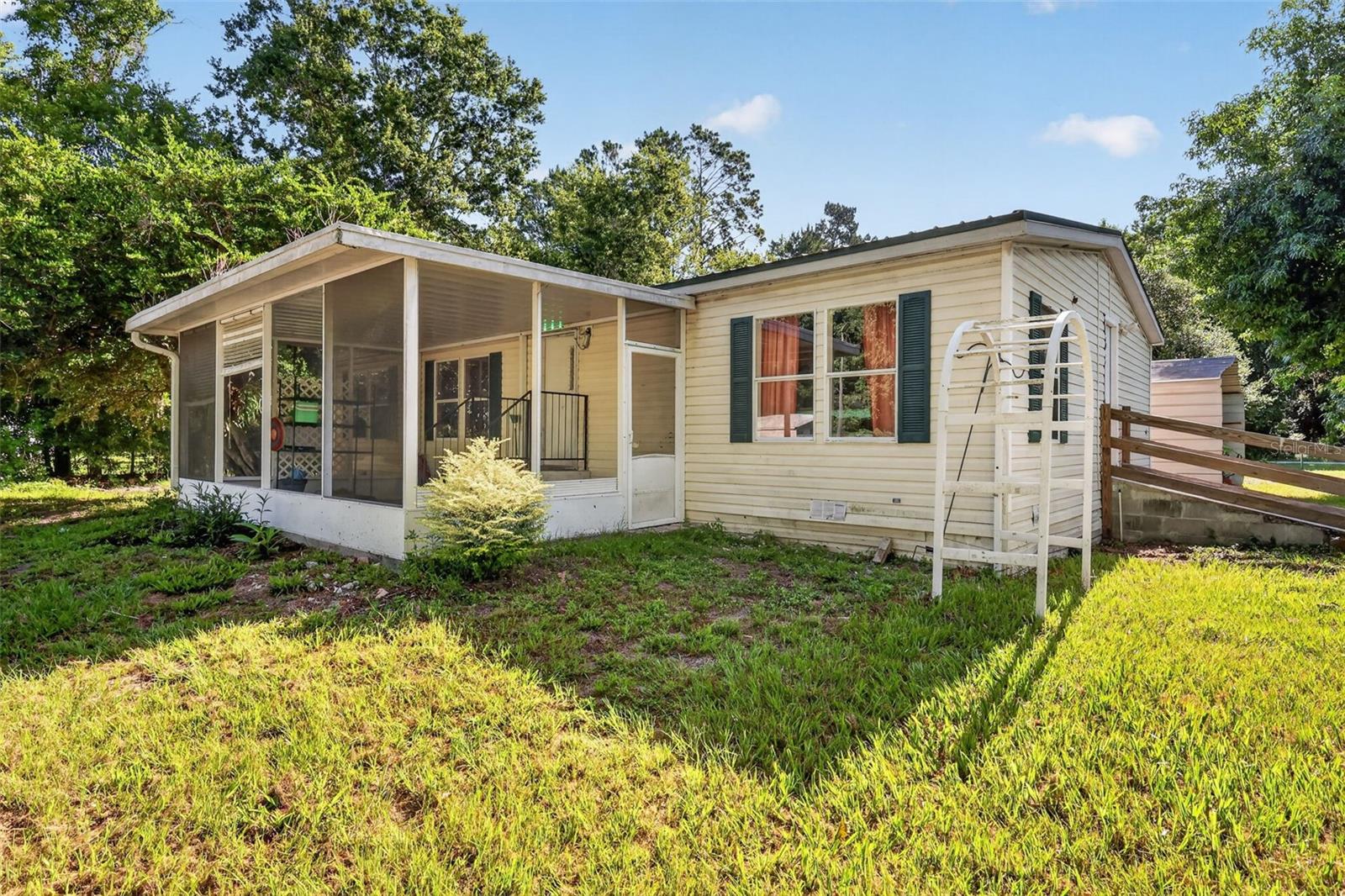 Escape the hustle and bustle with this rare acreage, just under 8 acres, offering  privacy and freedom, and no control from an HOA! Tucked away at the end of a long, secluded drive sits a 3 bedroom, 2 bath manufactured home waiting for your personal touch. Whether you choose to renovate the existing home, use it as a home base while you build your dream estate,  the infrastructure (well, septic, and power) is already in place. Surrounded by mature trees, small fishing pond and untouched nature, this is a blank canvas for homesteaders, investors, or anyone craving peace and quiet. Bring your tool belt and your imagination! Currently there is a separate detached workshop and 2 sheds, can you say many, many opportunities?! Located near the turnpike and approximately 45 minutes to Orlando and all the attractions.