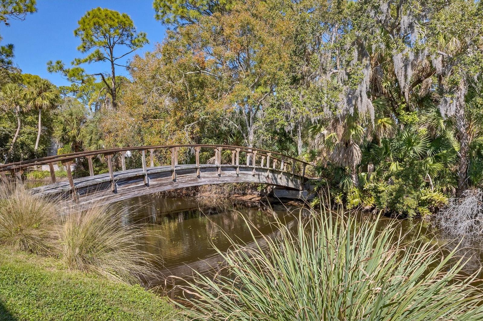 Welcome to Crooked Creek, a hidden gem in Sarasota with its own private gated access to the Red Bug Slough Preserve. This beautifully maintained 2-bedroom, 2-bath 2nd floor residence was completely updated in 2021 and offers serene views of Crooked Creek, a charming wooden bridge, and lush park-like surroundings. The open and airy floor plan features hardwood floors and tile throughout, plantation shutters, a skylight at entry, and modern finishes. The updated kitchen includes white cabinetry, solid surface countertops with a large peninsula, tile backsplash, smart stainless steel appliances ( fridge and dishwasher 2025, oven and microwave 2021), a spacious pantry, and a garden window. Additional updates are water heater 2018, and reverse osmosis for kitchen sink 2025. The primary suite enjoys peaceful water, a walk-in closet, linen closet and sliding doors to a covered screened lanai. The updated bath has a washer/ dryer (2021)in separate laundry closet, as well as tile floors, a modern vanity, and tile shower . The guest bedroom offers flexible use with a built-in workstation and queen-size Murphy bed. Additional features include two screened covered lanais, reverse osmosis water system for kitchen sink, covered carport, and ample guest parking. Crooked Creek is a 78-unit community offering a heated resurfaced pool, updated poolside kitchen, gazebo with seating, gas and charcoal grills, tennis/pickleball court, community storage with individual lockers, newer roofs (2021), new carports, and recently painted buildings. HOA fees have been reduced by $69 per month from 2025, reflecting strong reserves and excellent financial management. Conveniently located minutes from Siesta Key Beach, Gulf Gate, downtown Sarasota, shopping, and dining. A true nature lover’s paradise.