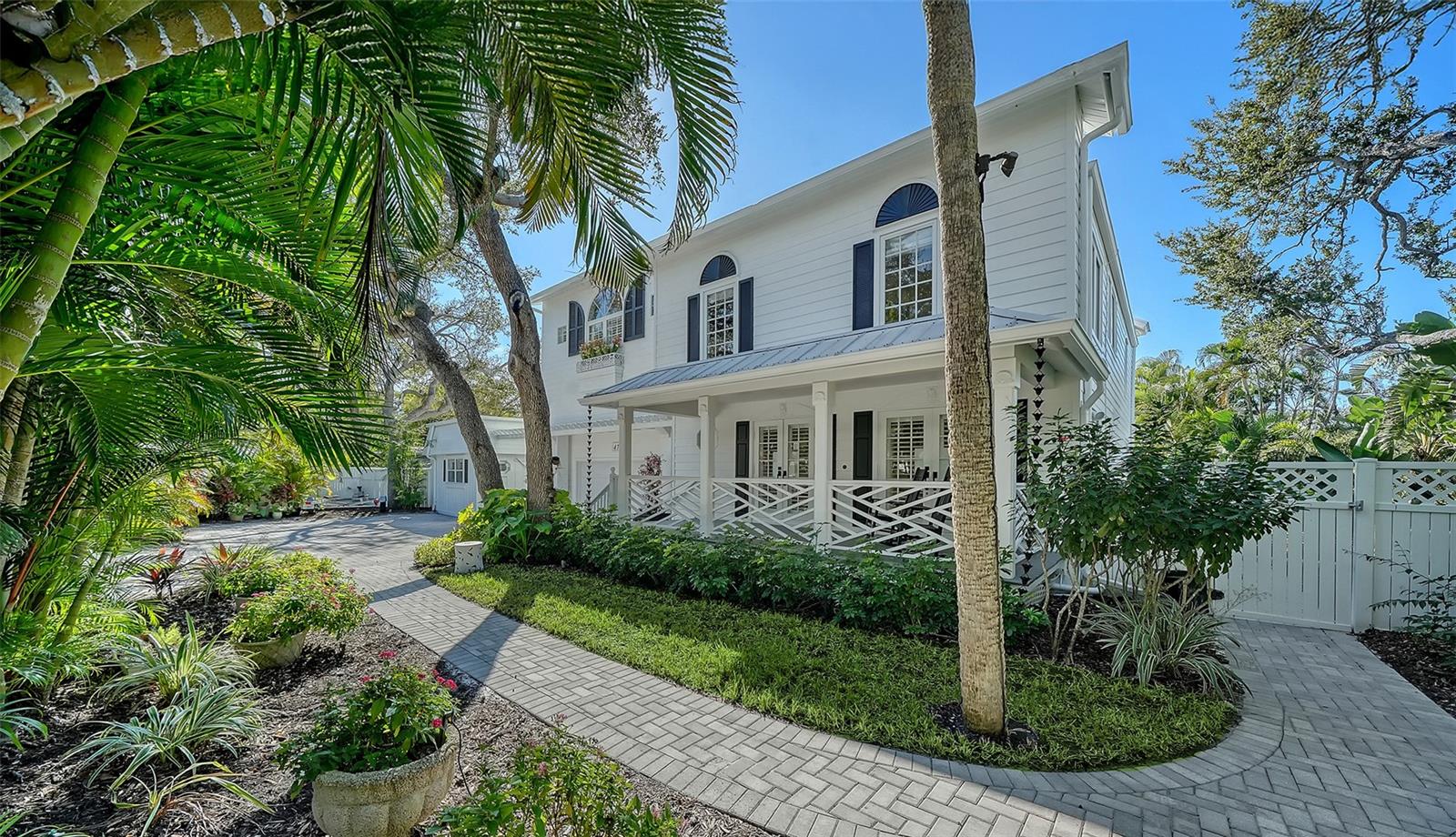 Gated Siesta Key Estate with Guest House & Boating Access.  
Experience the best of Siesta Key living, where award-winning white quartz sand beaches meet a relaxed island lifestyle, just minutes from Sarasota’s vibrant arts, dining, and cultural attractions.  Don’t be deceived by the 1977 construction date.  A 2003 addition doubled the size of this home.  Metal roof installed in 2017.  Pool and deck renewed in 2022.  Brand new elevated sea wall and dock in 2023.  2 new A/C systems in 2026.  And these are just some of the highlights.  Tucked inside its own gated enclave, this exceptional waterfront estate with a detached guest house is surrounded by lush tropical landscaping, creating a secluded oasis. The thoughtfully designed open floor plan offers many possibilities.  The kitchen serves as the heart of this home, opening seamlessly to a casual living area and dining space, while the expansive living room beyond features a fireplace and picture windows framing tranquil water and tropical views.  A versatile flex room at the front of the home easily adapts to your lifestyle — ideal as a home office, formal dining room, or playroom. Additional conveniences include a half bath and an oversized laundry room with access to a spacious two-car garage with abundant storage.  French doors at the rear of the home lead to the outdoor living area, where a heated saltwater pool and spa overlook peaceful canal views wrapping along the rear and side of the property.  Upstairs, the impressive primary suite offers a true retreat, complete with its own fireplace and a luxuriously appointed spa-style bathroom. A generous second bedroom features an ensuite bathroom, while two additional bedrooms share a third bathroom. Wood flooring, marble tile, high-end finishes, and distinctive architectural details are showcased throughout.  Adding flexibility, the detached guest suite includes a private entrance, studio, bathroom, kitchenette, and private courtyard — perfect for guests, multigenerational living, live-in staff, home office space, or fitness studio.  Boating enthusiasts will appreciate immediate access to the waterfront lifestyle with a private dock, 7,000-pound boat lift, plus an included 18-foot boat with trailer and two kayaks — ready for adventure from day one.  Ideally located in the heart of Siesta Key, the home is just steps from the Out-of-Door Academy school, and a walk or bike ride to Siesta Beach and Siesta Village. Convenient access to the north bridge makes reaching downtown Sarasota easy.  Offered turnkey furnished, this extraordinary property is move-in ready and perfectly suited as a primary residence, seasonal retreat, vacation home, or rental investment opportunity.