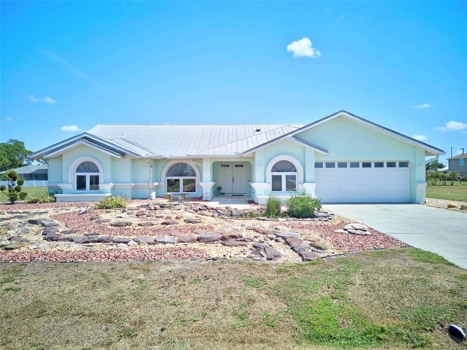 DEEP CREEK! Updated 3 bedroom, 2 bath pool home with oversized 2.5-car garage in highly sought after deed restricted community with county water and sewer! Low maintenance landscaping with double Koi pond exudes serene curb appeal. Step inside to over 2,300 sf of living area featuring cathedral ceilings, an abundance of natural light, neutral décor to pair with any color palette and large pocketing slider in living room seamlessly blending indoor and outdoor spaces. Beautifully remodeled kitchen offers custom cabinetry, granite counters and backsplash, high-end Fisher Paykel and Meile stainless appliances including double oven, cooktop with exhaust fan and large double sink prepping area for the gourmet chef. The casual dining nook overlooks spacious and bright family room which is a great space to relax or entertain. Generous primary suite features elegant lighting, access to lanai, pool views, oversized walk-in closet and luxurious private bath with dual sinks, soaking tub, and glass enclosed walk-in shower. Split floor plan provides privacy for all with two comfortably sized guest bedrooms and updated guest bath with soaking tub. Step outside to covered lanai and screened pool with cool deck offering plenty of room for entertaining and soaking up the sun. Large backyard overlooks greenbelt for added privacy and extra space for furry friends to roam. Additional features include A/C and new duct work (2020), hot water heater (2021), resurfaced pool (2024), security system, metal roof, hurricane rated garage door, extended garage with room to park golf cart plus impact resistant windows and metal panels for hurricane protection. Great location in a quiet and friendly neighborhood conveniently located close to I-75, restaurants, shopping, schools, parks, golf and just a short drive to downtown historic Punta Gorda, known for its world-class fishing and boating, community events and entertainment. Don’t miss this opportunity! Schedule your private showing today! Vacant lots adjacent to both sides of property are available for purchase separately.