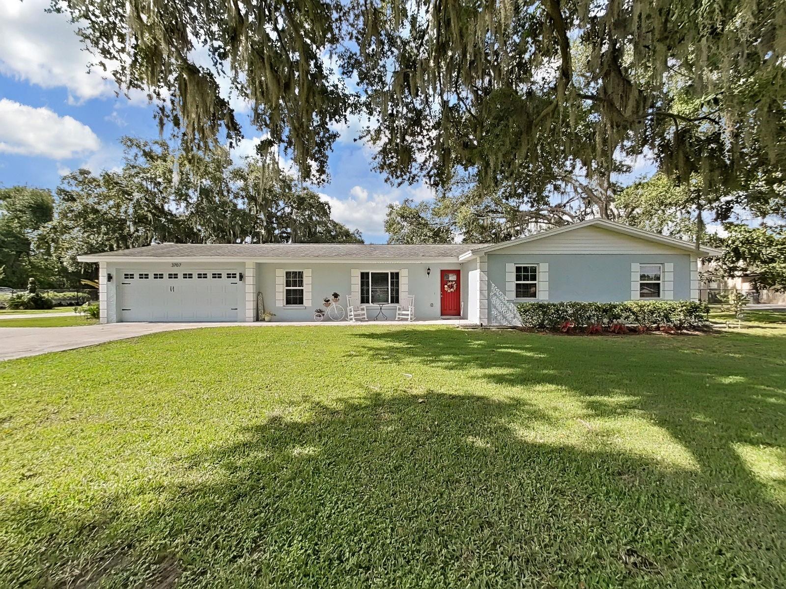 A beautiful 3 bedroom, 2 bath and 2 car garage home on an ACRE of land without HOA or CDD.   Great location on a corner lot with gorgeous oak trees. You are going to love the fruit trees – mango, avocado and lemon.  Plenty of room in the formal and family rooms and an OFFICE too!  Enjoy the sunsets from the front and rear porches (25’ X 12’ covered) and the fire pit.  This lovely home is fully chain link fenced complete with electric gate.  This home has been updated with granite in the kitchen and maple all wood kitchen cabinetry. The flooring is 1/8” bamboo engineered wood.  The master bath has granite double sinks with walk in shower.  Tile in the wet areas.  R-30 insulation.   Convenient car port conveys to buyer.  There are two closets in the master bedroom.  Good things to know about this home:  Convenient 2 door work shop (roof is only 2 years old). New drain field in 2019; Septic tank pumped March 2023; newer windows and last but not least  Oct 2023 new pump on the 145’ well.