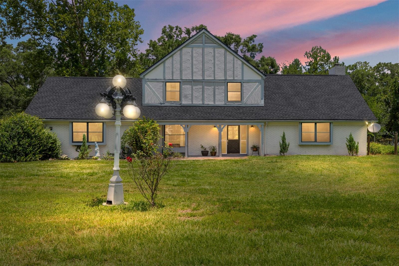 Tudor Charm Meets Horse Country Opportunity at 16353 NW 130th St., Williston, FL.  Perfectly positioned for the Winter Horse Show Circuit, this distinctive two-story Tudor-style home sits on 3.13 unrestricted acres in the heart of Williston's equestrian corridor, less than 10 minutes from HITS Ocala, approximately 20 minutes from the World Equestrian Center, and within easy reach of Black Prong Equestrian Village and Goethe State Forest. With 5 bedrooms, 2.5 baths, two barns (4 stalls total), 5 paddocks, and a workshop, this property is ready to work as hard as you do. Whether that means housing your horses, hosting your team, or generating income as a short-term rental, the flexibility is built right in. The 5-bedroom layout is ideally suited for Airbnb during show season, and short-term rental demand in the area is proven. The home is well maintained with meaningful updates including a brand new roof, new HVAC, a renovated upstairs bathroom, and fresh interior paint throughout. The Tudor architecture gives it genuine curb appeal and character that stands apart from the typical Florida ranch. No HOA. No restrictions. Priced at the recent appraised value. Whether you're a competitor looking for a show season base, a family seeking acreage and freedom, or an investor eyeing Florida's booming equestrian rental market, this property checks a remarkable number of boxes at a price point that's increasingly hard to find this close to the action.