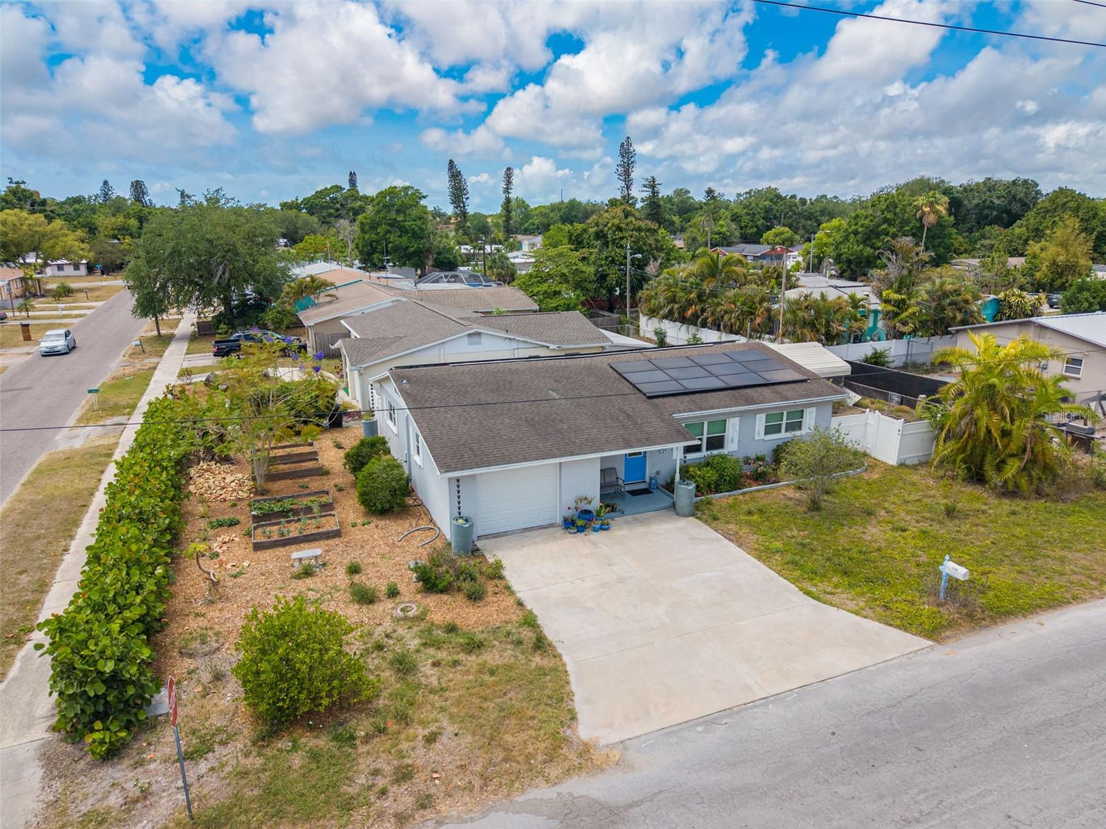 **Eco-Friendly Oasis on a Corner Lot: Updates, Solar Power, and Prime Gulfport Location!** Discover the perfect sanctuary for the environmentally conscious resident in this fully updated, low-maintenance home. This solid BLOCK construction home sits on a desirable CORNER LOT and features 3 bedrooms and 2 full baths, all with beautifully preserved terrazzo floors throughout (except in 1 bathroom). Parking is easy with an oversized 1-car garage and spacious driveway.  Worry-free living is assured with major systems replaced in 2015, including a new ROOF, HVAC, DUCTWORK, ATTIC INSULATION, ELECTRICAL PANEL, and IMPACT windows and doors. A 2018 TANKLESS water heater adds to the efficiency.  Live nearly off-grid thanks to SOLAR PANELS installed in 2016 and 2020, resulting in incredibly low monthly electric bills that often range from $0 to $30.  This property is a dream for gardeners and homesteaders, featuring 4 raised garden beds, rain chains, and 6 rainwater catching barrels. Enjoy fresh produce from numerous fruit-bearing trees and plants, including fig, Meyer lemon, banana, papaya, Thai lime, dragon fruit, pineapple, and blackberries. For peace of mind, the home is located in Flood Zone X, meaning flood insurance is typically not required, and is situated in a Non-Evacuation Zone, approximately 28 feet elevation. The location is unbeatable: enjoy a short bike ride to downtown Gulfport's restaurants and recreation, or hop on the Pinellas Trail just a few blocks away.