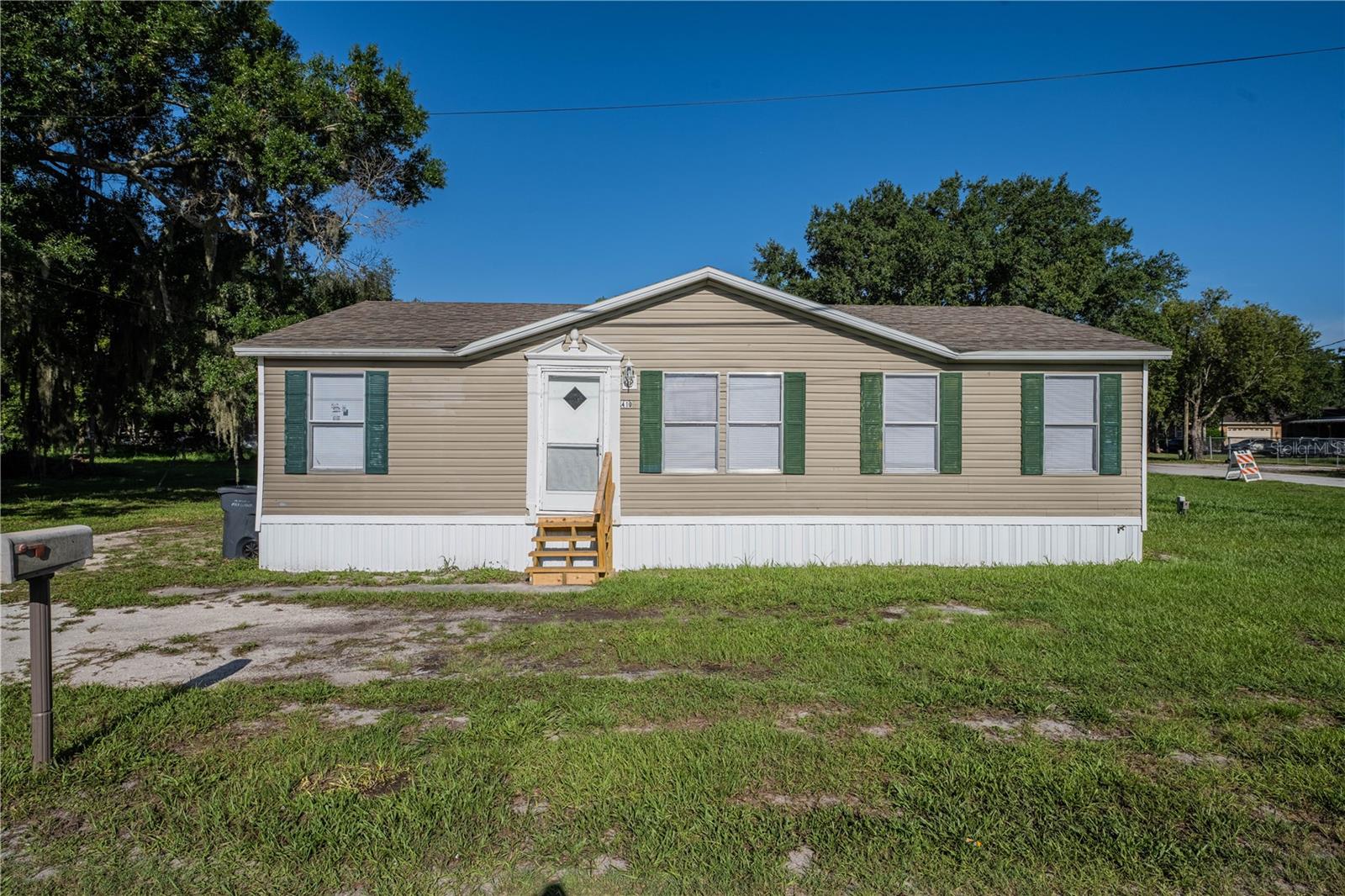This charming 3 BEDROOM 2 BATH SPLIT PLAN DOUBLEWIDE MANUFACTURED HOME is ready for a new owner! Upon entering the home, you'll notice the SPACIOUS LIVING AREA with the primary suite to the right and the other bedrooms to the left. There's NO CARPETING in this home - NEW LAMINATE FLOORING was recently installed throughout. The kitchen has NEW LOWER CABINETS. Both bathrooms have NEW TOILETS AND VANITIES, and the guest bath has a NEW TUB/SHOWER UNIT. There is a LAUNDRY CLOSET that is conveniently located just off the kitchen. Enjoy your morning coffee on the COVERED BACK PORCH that overlooks the back yard. This home is located on a SPACIOUS CORNER LOT in the Wahneta area of Winter Haven where you don't have to worry about deed restrictions as there is NO HOA. The roof was replaced in 2017 and the AC in 2025.