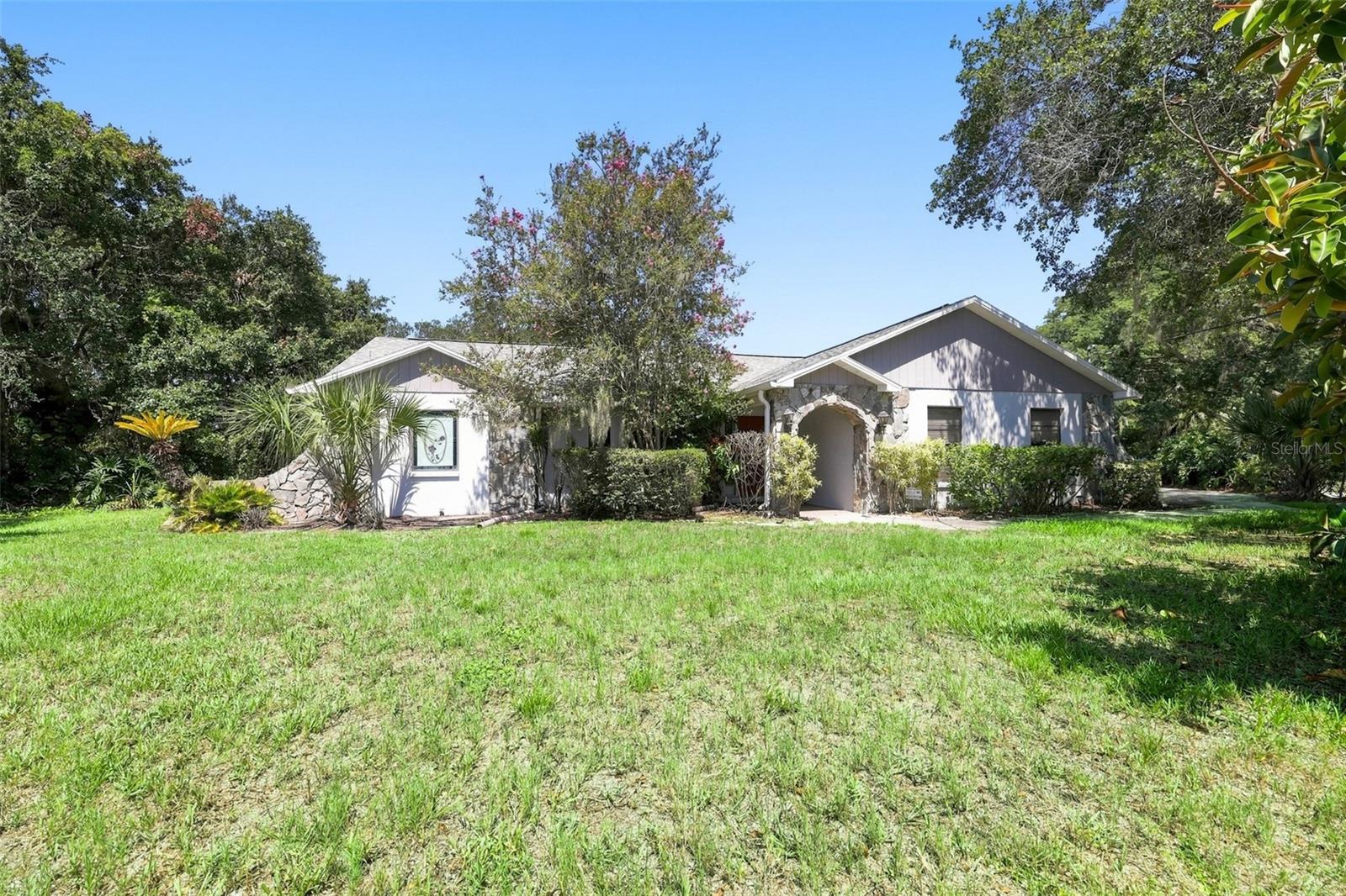 Rare opportunity to own a waterfront pool home on an oversized 0.66-acre (160' x 180') lot in an established Riverview neighborhood with NO HOA and NO CDD. Bring your boat or RV and enjoy the peaceful waterfront lifestyle on 20-acre Lake Kenda, with the opportunity to add your own private dock (buyer to verify permitting requirements). The property also includes a detached wood workshop/storage room with a matching roofline, lighting, and electricity, making it ideal for a workshop, hobbies, or additional storage. This 3-bedroom, 2-bath home offers approximately 1,930 square feet of living space and features a desirable split-bedroom floor plan, a spacious family room centered around a beautiful wood-burning fireplace, a formal living and dining room, dinette, Florida room featuring NEW WINDOWS and DOUBLE SLIDERS with beautiful lake views, and an indoor laundry room. Step outside to the screened pool with brick paver decking, surrounded by mature landscaping and overlooking the lake—an ideal setting for relaxing, entertaining, fishing, or simply enjoying the peaceful waterfront views. The pool is fully operational and functioning; however, it may require resurfacing. The home offers an excellent opportunity to update the interior to your personal style while benefiting from several major improvements already completed (NEW ROOF – July 2021, NEW A/C UNIT – February 2025, NEW POOL PUMP, NEW WINDOWS and DOUBLE SLIDERS in the Florida room, and WATER HEATER approximately 2–3 years old). Conveniently located near shopping, dining, schools, hospitals, public transportation, and major commuter routes, this property combines space, privacy, and waterfront living in one of Riverview's most desirable settings.