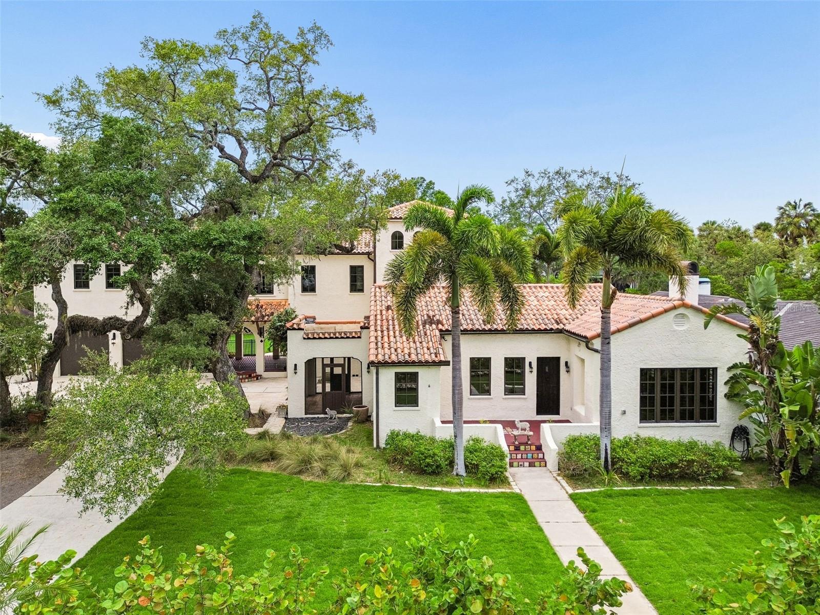 One of Sunset Park's rare surviving 1920s estate homes, this extraordinary Mediterranean residence evokes the timeless elegance of Palm Beach's golden era while offering the comfort, functionality, and infrastructure expected by today's luxury buyer. Situated on nearly one-half acre beneath a canopy of majestic oaks and mature Florida palms, the property offers a setting that recalls Old Florida elegance while benefiting from an extensive 2025-2026 renovation and modernization.
Approximately $500,000 was invested in carefully planned improvements, including more than $100,000 in electrical and infrastructure upgrades. The renovation was undertaken with a singular goal: modernize the home for contemporary living while meticulously preserving the historic details that make it irreplaceable. The result is a seamless balance of old and new. 
The redesigned kitchen and living spaces have been opened to create exceptional flow for everyday living and entertaining. Original architectural elements, including character-rich details that reflect the home's 1924 heritage, remain integral to the residence, while updated finishes, systems, and living spaces provide modern convenience throughout.
Offering over 5,000 square feet of living space, the home features three generous gathering rooms downstairs, with one featuring a gorgeous gas fireplace reminiscent of the Great Gatsby era. In the kitchen, architectural-quality cabinetry throughout, punctuated by new stainless Jenn-Air appliances. There is an integrated food preparation or planning/study nook with ample counter space, and a large walk-in pantry. A breakfast room featuring tall carved wood panel doors offers a sunny space for dining.  Downstairs also offers two large bedrooms with ensuite bathrooms, a large laundry room and a mudroom with a convenient pool bath. Upstairs, the large primary bedroom is adjacent to the primary bathroom suite appointed with every upgraded fixture and feature, complete with an extraordinary window-lined dressing room featuring nearly 20-foot ceilings. Adjacent to the primary suite is a spacious executive office with elevated views and an exposed brick accent wall, ideal for a home-based business or private retreat. Large windows frame expanded views of the lush grounds, creating a connection between the interior and the estate-like setting outside. The upstairs level is completed by an unusually large separate guest/in-law studio with kitchenette, a full bathroom with its own laundry connections, and its own private entrance.
The private backyard is designed for entertaining and relaxation, anchored by a large saltwater pool and expansive outdoor living areas surrounded by mature landscaping and abundant green space. Few properties in South Tampa offer this combination of privacy, scale, and character. Adding to the property's uniqueness is a tidal canal at the rear of the property, providing opportunities for kayaking and exploration through the surrounding mangroves offering a connection to nature rarely found in the heart of South Tampa. 
A truly one-of-a-kind South Tampa residence in the best school district where historic charm, modern functionality, and an exceptional setting come together in a way that cannot be replicated.