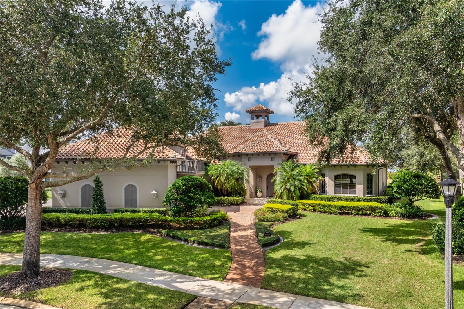 Keene's Pointe - Gated/24-hour attended community in highly desired Windermere, Florida. This beautiful custom-built home is located on the 5th green of The Golden Bear Club, an 18-hole golf course designed by Jack Nicklaus featuring golf, tennis, fitness, swimming and dining.  Built with the Florida lifestyle in mind, the open concept floor plan boasts a family room with wet bar, formal dining room, functional kitchen with high-end appliances, large pantry and breakfast area with wet bar/coffee station, large office with built-in desk and cabinetry and walk-in closet, primary suite with sitting area and spacious bath and walk-in closet.  Located privately on the other side of the home are two ensuite bedrooms with walk-in closets, the laundry room and staircase leading upstairs to the fourth bedroom and bath with Murphy bed, walk-in closet and balcony overlooking the front courtyard.  This home offers an abundance of closets and storage areas including the large mechanical/storage room on the second floor - perfect for storing holiday decor.  No detail was spared from the travertine flooring, lightning arrestors, central vac system, power shades, to the beautiful tray and coffered ceilings.  NEW ROOF IN 2025. Truly depicting outdoor living, there is a screened pool/spa with over 3,000 sf of outdoor living area including a fully functional outdoor kitchen with grill, burners, sink, and refrigeration, and a fireplace.  Winding down after a day of work or golf, entertaining or just enjoying the pool is easy with the beautiful sunset over the golf course and lake, and of course, Disney fireworks.  This home also has an oversized 3-car garage with additional golf cart garage which can easily accommodate your favorite cars.  Located in close proximity to shopping, dining, major expressways and tourist attractions, as well as top-rated public and private schools.  This can be all yours to call HOME!