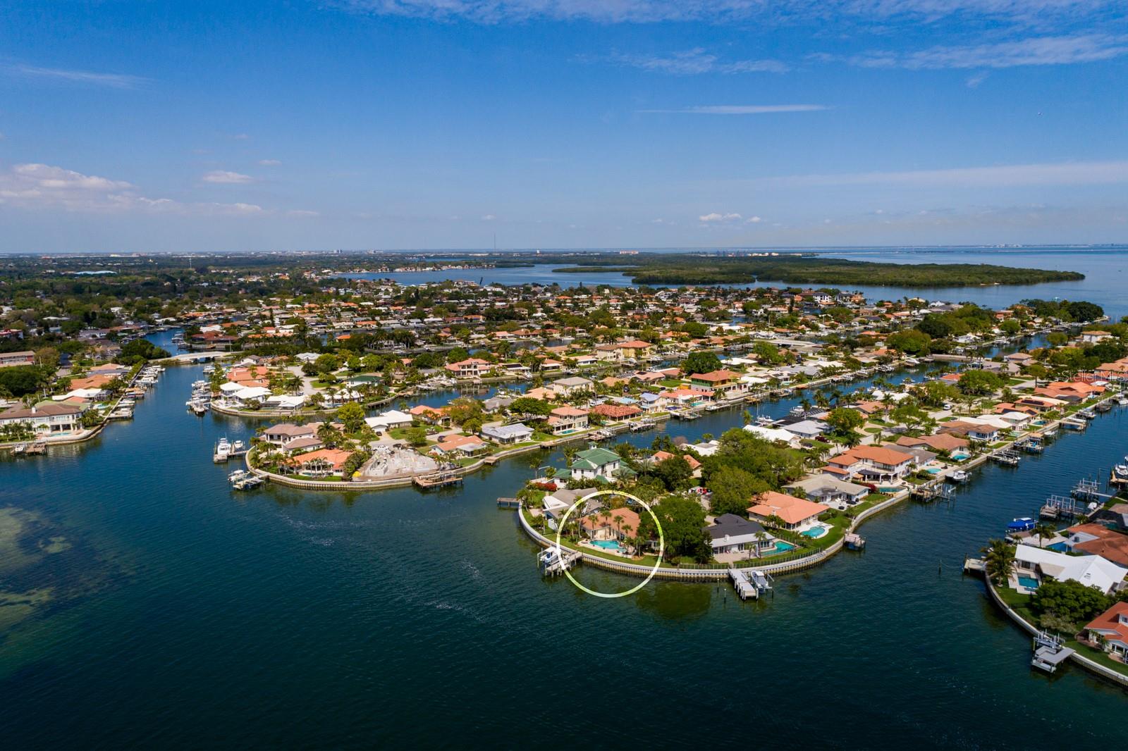 Experience the epitome of waterfront living with a breathtaking 139-foot OPEN WATER PANORAMA, stretching from a tranquil sunrise over Apollo Beach to the procession of cruise ships beneath the Sunshine Skyway Bridge. As night falls, delight in the multicolor light show on the bridge & downtown's skyline often illuminated with celebratory fireworks, creating an unrivaled vista in a coveted Venetian Isles “point” property. Imagine waking up to spectacular sunrises, dolphins frolicking & graceful manatees while sipping your morning coffee.
Nestled at the tip of a serene CUL-DE-SAC this exceptional lot was handpicked by Venetian developer Mark Sibley to build his personal home. A tropically landscaped yard welcomes you, leading to a secluded gated courtyard complete with a soothing fountain. Once inside the courtyard, you'll be immediately drawn towards the captivating waterfront scenes that beckon you inside. It is an over the top “WOW” view. As you step inside, the world beyond fades away, replaced by the mesmerizing OPEN BAY VISTA that greets you.
Transparent living spaces seamlessly flow to the luxurious pool deck, worry-free seawall, and a private dock offering front-row seats to Tampa Bay's vibrant marine life. A step-down dock provides easy access for visiting boats, paddle boards and kayaks.  The state-of-the-art dock with cool Thru-flow decking, offers a 16,000# dual-motor boat lift that grants quick water access by boat!  Explore the bay's pristine waters or leisurely voyage to vibrant downtown St Pete with hourly dockage slips readily available allowing you to explore a tapestry of the best of St Pete: Saturday morning markets, world-renowned art museums including the Dali Museum, diverse award-winning restaurants, boutique shopping and the Pier. Back inside, the architecturally designed Allikristé kitchen, resplendent with decorative wood beams, a Copper farm sink and Copper rangehood, marry functionality with decorative flair. Open shelving and glass-paneled cabinet doors add a touch of openness. chef will love the Sub-Zero refrigerator and 6 burner dual-fuel Dacor gas stove with a convection oven making culinary endeavors a delight. Adjacent to the kitchen, the glass dining room offers unobstructed views of the bay and leads seamlessly to the lanai, ideal for alfresco dining or sipping a glass of wine at sunset. The family room, adorned with bespoke craftsmanship boasts a custom “hidden TV” cabinet above an arched gas fireplace, perfect when the rare winter evening beckons for coziness. Retreat to the sumptuous primary suite, where you are beckoned to the pool deck. Complete with a walk-in closet, sitting area and a luxurious ensuite bath featuring a jetted tub, walk-in shower, and dual vanities. This sanctuary promises ultimate relaxation. A waterfront guest suite, appointed with an ensuite bath, offers direct access to the pool, ensuring comfort for discerning guests. Three additional bedrooms provide ample space for family, guests or a dedicated home office. One bedroom/office is elegantly finished with hand crafted cabinetry, perfect for showcasing personal collections and treasured books. This is not just a HOME, it's a sanctuary of opulence. If you must venture out, Whole Foods, Publix & Trader Joe’s are close by. Beach enthusiasts: the award-winning Gulf Beaches are a short drive away. Golfers: the Vinoy & Mangrove Bay Golf Courses are nearby. This residence is more than just a home; it's your FLORIDA DREAM realized! Bedroom Closet Type: Walk-in Closet (Primary Bedroom).