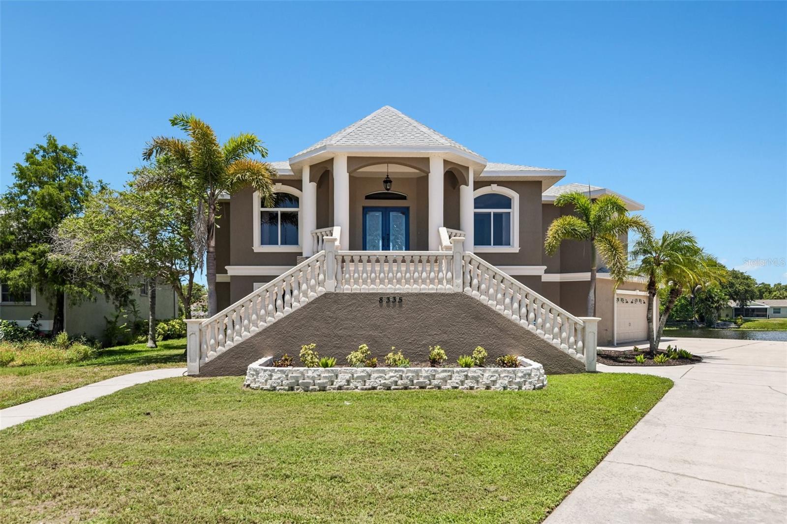 Virtually Staged. Situated on a premium 1/3-acre lot within an exclusive subdivision, the spectacular, custom-built estate at 8335 Cheyenne Dr offers luxury waterfront living at its finest. This exceptional 4-bedroom, 3.5-bathroom home boasts a brand-new roof (2025) and an expansive design featuring a bright, open upper level with high ceilings, durable tile and laminate flooring, and an elegant formal dining room. Rich maple cabinetry and premium granite countertops anchor the gourmet kitchen—complete with a double built-in oven—and carry beautifully throughout the property, including into the massive, private primary suite which serves as a personal oasis with a spa-like Jacuzzi tub and separate glass shower. Downstairs, an incredible 2,700+ square foot lower level offers endless possibilities for a game room, home gym, or workshop alongside an oversized 3-car garage. Beyond the breathtaking views from the home, premier outdoor recreation is effortlessly accessible; an easy 5-minute walk brings you to the neighborhood pedestrian gate entering Lake Seminole Park, a 258-acre wildlife habitat featuring miles of paved and unpaved trails, a ballfield, a large playground, and a boat ramp for launching your kayak, jetski, or motorboat. Additionally, the scenic Seminole Waterfront Park is just a 3-mile drive away, offering another fantastic playground and a perfect spot to launch a kayak into Long Bayou.