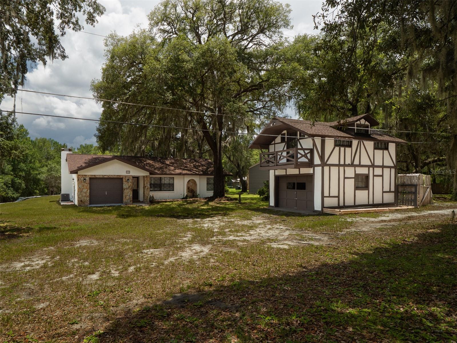 Searching for a carefree home in the peaceful Melrose area? This beautifully refurbished 2-bedroom, 2-bath concrete block home sits on 2 mostly cleared acres with nearly every major update already completed for worry-free living. Recent improvements include a new HVAC system, new roof on the home (installed in late 2023), a months-old roof on the detached two-story Tudor-style garage, new appliances, new well pump, new water heater, new 110-volt wiring throughout both levels of the detached garage, new porcelain tile and flooring throughout the home, and updated plumbing fixtures. The septic system was pumped and inspected at the end of 2023, and a spacious concrete patio provides the perfect space for outdoor entertaining. The detached Tudor-style garage offers endless possibilities as a she shed, home office, workshop, or guest space, while the attached garage could potentially be converted into a third bedroom. A professionally installed 4-foot retaining wall spanning approximately 50 yards elevates the home's grade for added peace of mind regarding wetlands and insurance. The seasonal Lake at the rear of the property varies with annual rainfall, adding a natural backdrop to the property. A private driveway leads to the home and only two quiet neighbors, with convenient curbside garbage pickup. Survey available upon request. Located just about 20 miles from Gainesville and 25 miles from Palatka with minimal traffic, you'll enjoy the charm of historic Melrose, featuring local shops, boutiques, restaurants, a farmers market, ACE Hardware, and a Winn-Dixie just a couple of miles away. This move-in-ready property combines country tranquility with modern updates and small-town convenience.