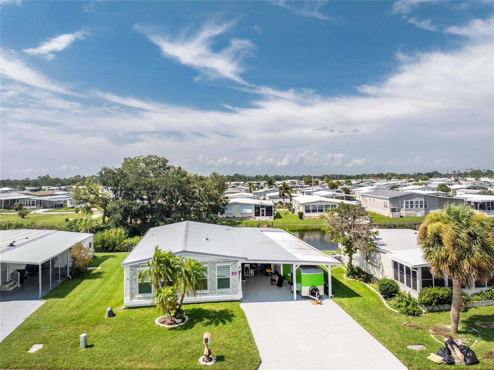 This beautifully renovated two-bedroom, two-bathroom mobile home offers an exceptional blend of contemporary, coastal, waterfront, and Florida styles, creating a stunning and unique living space. Recently gutted and expanded to over 1300 square feet, every corner of this home features something new and delightful. Situated on a waterfront lot with direct canal access to open water, this property is a paradise for boating enthusiasts and nature lovers alike. Upon entering, you'll be welcomed by spacious rooms enhanced by pocket doors, ensuring an open and airy feel throughout. The large living areas seamlessly connect to a newly upgraded kitchen, complete with a generous island, stainless steel appliances, and elegant quartz countertops. The attention to detail is evident with new plumbing, electrical systems, a metal roof, and new windows and doors, ensuring modern comfort and efficiency. The home boasts a variety of outdoor spaces perfect for relaxation and entertainment. A screened porch provides a serene spot to enjoy the view, while a deck and patio offer additional areas to bask in the Florida sunshine. The epoxy driveway leads to a convenient workshop and storage area, catering to all your practical needs. Inside, an office space provides a quiet retreat for work or study, and an inside laundry room adds to the home's functionality. The en suite primary bedroom is a true retreat, featuring a large closet and a beautiful view of the canal. This private oasis is complemented by updated bathrooms with contemporary finishes, enhancing the home's modern aesthetic. The property's exterior is equally impressive with a stone front and a durable concrete seawall that lines the canal. The new floors and subfloors throughout the home add to its fresh, updated feel. With an HOA fee of only $175 monthly, this home offers affordable luxury in a prime waterfront location. Beyond the home itself, you'll find a vibrant and active community with a wealth of amenities. The community features a large conference room with a banquet hall, perfect for gatherings and events. Two pools and a hot tub provide ample opportunities for relaxation and recreation. Additionally, a marina with open docks is available at an extra cost for those who love boating. This mobile home is more than just a place to live; it's a lifestyle. Every element has been carefully considered to provide comfort, style, and convenience, making it a perfect haven for those seeking a beautiful and functional waterfront property in an active and welcoming community.