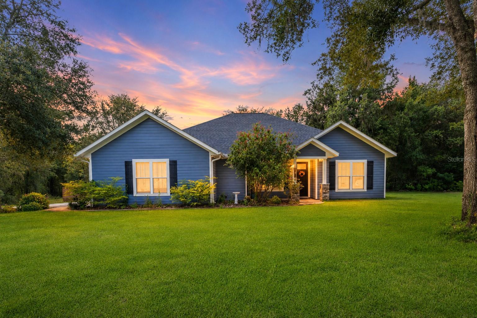 Built in 2022 by respected local builder Norfleet Homes, this beautifully crafted 4-bedroom, 3-bathroom residence offers the quality and comfort of newer construction on 4.78 peaceful acres in the desirable Woods of Alchrist community. Norfleet Homes has deep roots in North Central Florida and is known for thoughtfully designed, energy-efficient custom homes created to complement the land and lifestyle of the area. Inside, the home provides 2,065 square feet of inviting living space with a modern layout designed for both everyday comfort and entertaining. Its newer construction offers contemporary finishes, improved efficiency, and added peace of mind without the immediate projects often associated with an older home. The spacious acreage is partially fenced and provides an exceptional combination of cleared outdoor space, natural surroundings, privacy, and versatility. Located just across the Alachua County line in Gilchrist County, this property allows you to enjoy a peaceful country setting and the appeal of Gilchrist County’s lower property-tax environment while remaining conveniently connected to High Springs, Newberry, Alachua County, and Gainesville. Gainesville’s employment centers, shopping, dining, healthcare, and entertainment are still within a comfortable drive, making it possible to enjoy space and tranquility without feeling disconnected from everyday conveniences. Woods of Alchrist is known for its spacious homesites, custom-built residences, and relaxed rural atmosphere. Whether you envision a garden, outdoor entertaining area, space for recreational activities, or simply more room to breathe, nearly five acres gives you the freedom to make the property your own. Newer Norfleet construction, nearly five acres, a beautiful natural setting, and convenient access to both Gilchrist and Alachua counties make this property a rare opportunity to enjoy refined country living near Gainesville.
