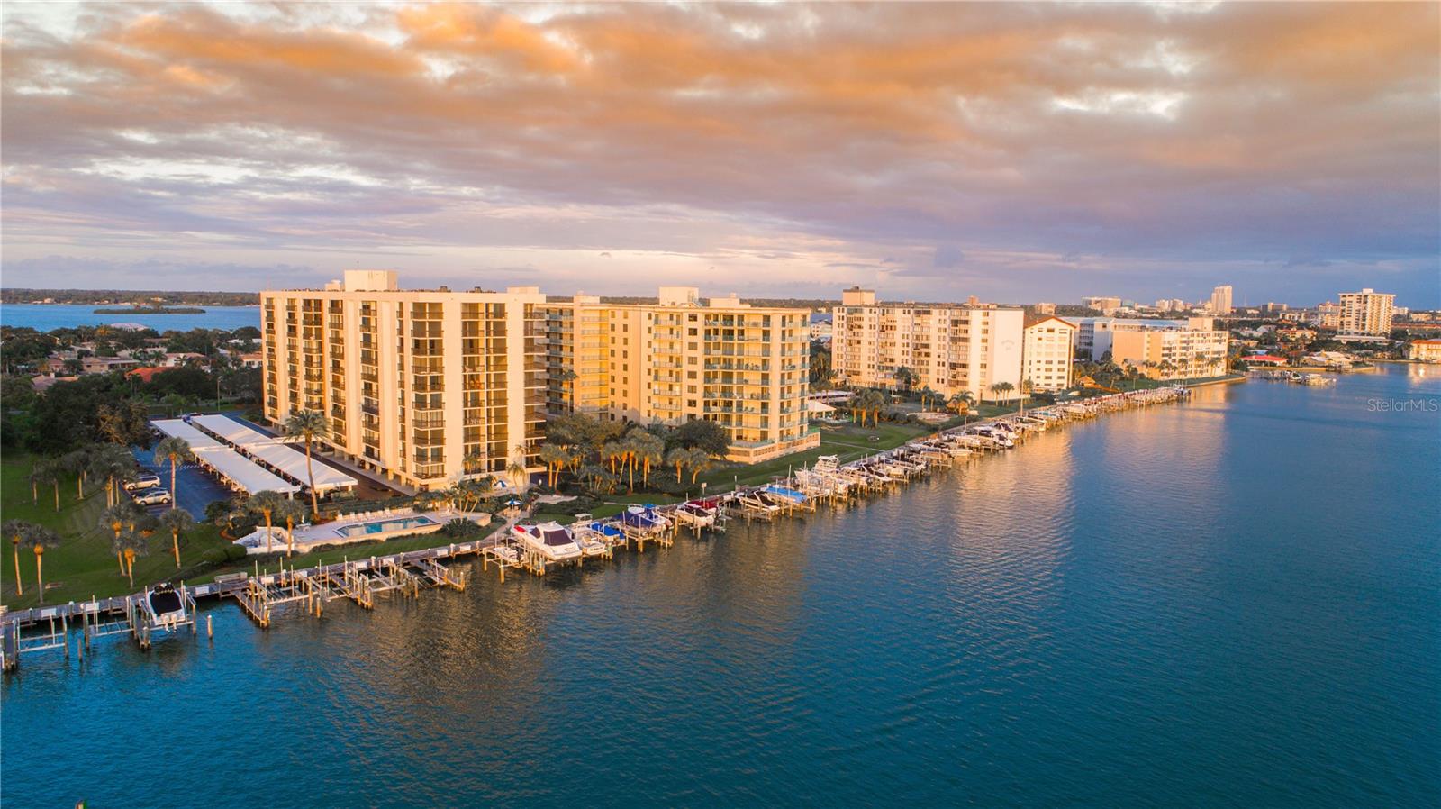 WOW!!! 9th FLOOR CORNER END UNIT!!! TWO BALCONIES!!! PANORAMIC INTRACOASTAL AND GULF WATER VIEWS with SPECTACULAR SUNRISES and SEASONAL SUNSETS! This rarely available 1,500 sq. ft. corner residence, the largest floor plan in the desirable ISLAND WALK WATERFRONT COMMUNITY, offers a layout that lives like TWO PRIVATE PRIMARY SUITES, each with balcony access and exceptional water views. The UPDATED OPEN KITCHEN is perfectly positioned to capture breathtaking views stretching north to the Dunedin Causeway and beyond while opening seamlessly to the spacious living and dining areas, creating the perfect setting for everyday living and entertaining. Tile flooring throughout, UPDATED KITCHEN, UPDATED BATHROOMS, and a dedicated guest half bath make this truly MOVE-IN READY. Enjoy your morning coffee from the additional east-facing kitchen balcony with views toward downtown Clearwater. For added peace of mind, this home features HURRICANE-RATED SLIDERS, a NEW 2026 AIR CONDITIONING SYSTEM, and a NEW 2026 REFRIGERATOR. Additional highlights include a CLIMATE-CONTROLLED STORAGE UNIT (S-92) conveniently located just outside the unit entrance and UNDER-BUILDING PARKING SPACE #105. Monthly HOA fees include cable, internet, water, sewer, trash, exterior building maintenance, professional property management, and flood insurance. Island Walk features a 2019 roof, RECENT EXTERIOR PAINTING, completed balcony and railing restoration with durable Gemstone finish, and has successfully completed both the Milestone Inspection and SIRS requirements, providing added confidence and peace of mind for future owners. Residents enjoy a waterfront heated pool and spa, shared tennis and pickleball courts, dual grilling stations, multiple outdoor dining and gathering areas, bike storage, and a secured lobby with an updated entry system. PET FRIENDLY (2 pets up to 25 lbs. each) and RENTAL FRIENDLY (3-month minimum, twice annually), with marina slips periodically available for rent or purchase through private owners. Ideally located in the SELF-CONTAINED WATERFRONT COMMUNITY OF ISLAND ESTATES, you'll enjoy nearby shopping, dining, banking, a grocery store, the Clearwater Marine Aquarium, and you're just minutes from the WORLD-FAMOUS SUGAR SAND BEACHES OF CLEARWATER BEACH. Whether you're searching for a full-time residence, seasonal getaway, investment property, or a 1031 exchange opportunity, this EXCEPTIONAL WATERFRONT CONDOMINIUM is ready for you. Just bring your suitcase and start living the Florida coastal dream! Come Live at Island Walk on Island Estates! Come Live the Lifestyle! Come Live on the Island!
