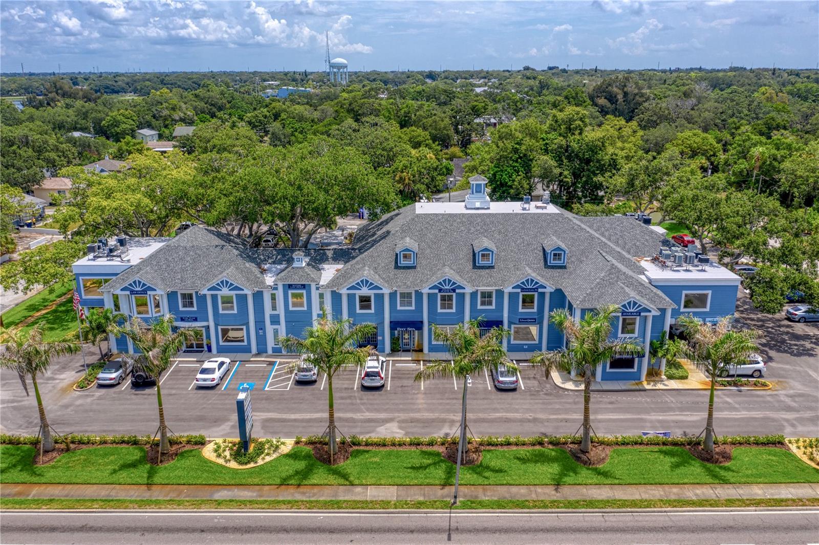 Belleair Landing is a highly recognizable landmark office building ideally positioned at the signalized corner of S. Fort Harrison Avenue and Belleview Boulevard, directly across from the Belleair Country Club Golf Course. This iconic two-story professional property features 16 office suites and is home to a diverse mix of well-established local and national businesses. The building is anchored by the beloved Wildflower Café, a popular destination for both year-round residents and seasonal visitors. Constructed of solid concrete, the property offers abundant on-site parking and has benefited from numerous recent capital improvements, including a newer roof, fresh exterior paint, a newly paved parking lot, and lush, updated landscaping. Inside, the impressive lobby creates a warm and welcoming atmosphere, featuring an elevator and sweeping staircase—an environment professionals are proud to call home. Located just outside of Belleair in one of Pinellas County’s most visible and sought-after corridors, Belleair Landing stands out with its stately architecture and signature blue exterior, making it one of the area’s most recognizable commercial properties. Additional highlights include prominent building signage and a tall, illuminated pylon sign providing outstanding exposure along heavily traveled Fort Harrison Avenue, the primary thoroughfare connecting Largo and Clearwater. Centrally located near the Pinellas Trail, Pelican Golf Club, and just minutes from world-famous Clearwater Beach, this is a rare opportunity for an owner-user or investor to acquire a premier office asset in an exceptional location.