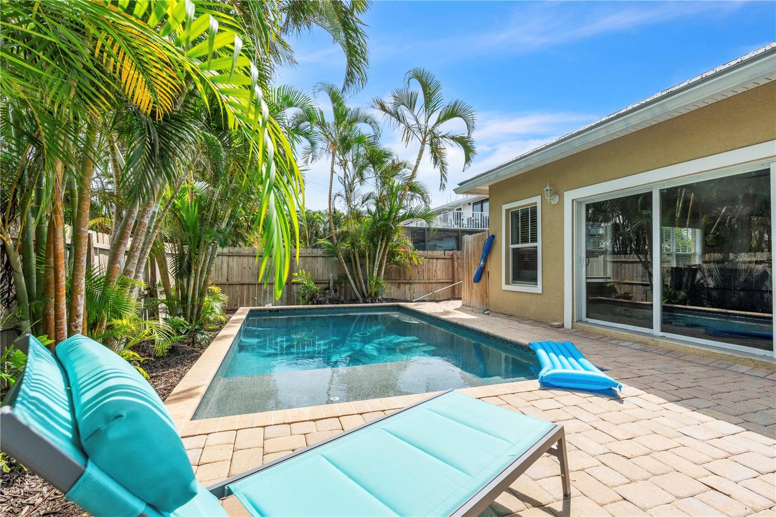 The fabulously updated kitchen and open floor plan, make this 3 bedroom/2 bath half duplex a picture perfect island escape.  Ideally situated on a quiet corner lot in the heart of the island, it is a straight walk down the street to the sugar sand beach, making it a popular vacation rental too!  The split bedroom plan is perfect for hosting, and the updated, private, heated pool and trellis invite you to step out your wall of sliders and enjoy the Florida sunshine.  You will love the coastal charm of the beach inspired décor, with wainscoted walls, freshly painted interior, white wood trim, tile flooring throughout, recessed lighting, stainless steel appliances, quartz counters, farmhouse sink and white shaker style cabinetry to the ceiling.  Step out for a dip in the pool from your large primary en suite with high ceilings, and a bathroom with dual vanity and a walk in shower.  Your spacious guest rooms on the other side of the house, are privately situated and enjoy ample natural light through large windows.  This slice of paradise is perfectly situated, with easy beach access and just down the street from the free trolley stop.  Enjoy your island time stress free in this like-new home!