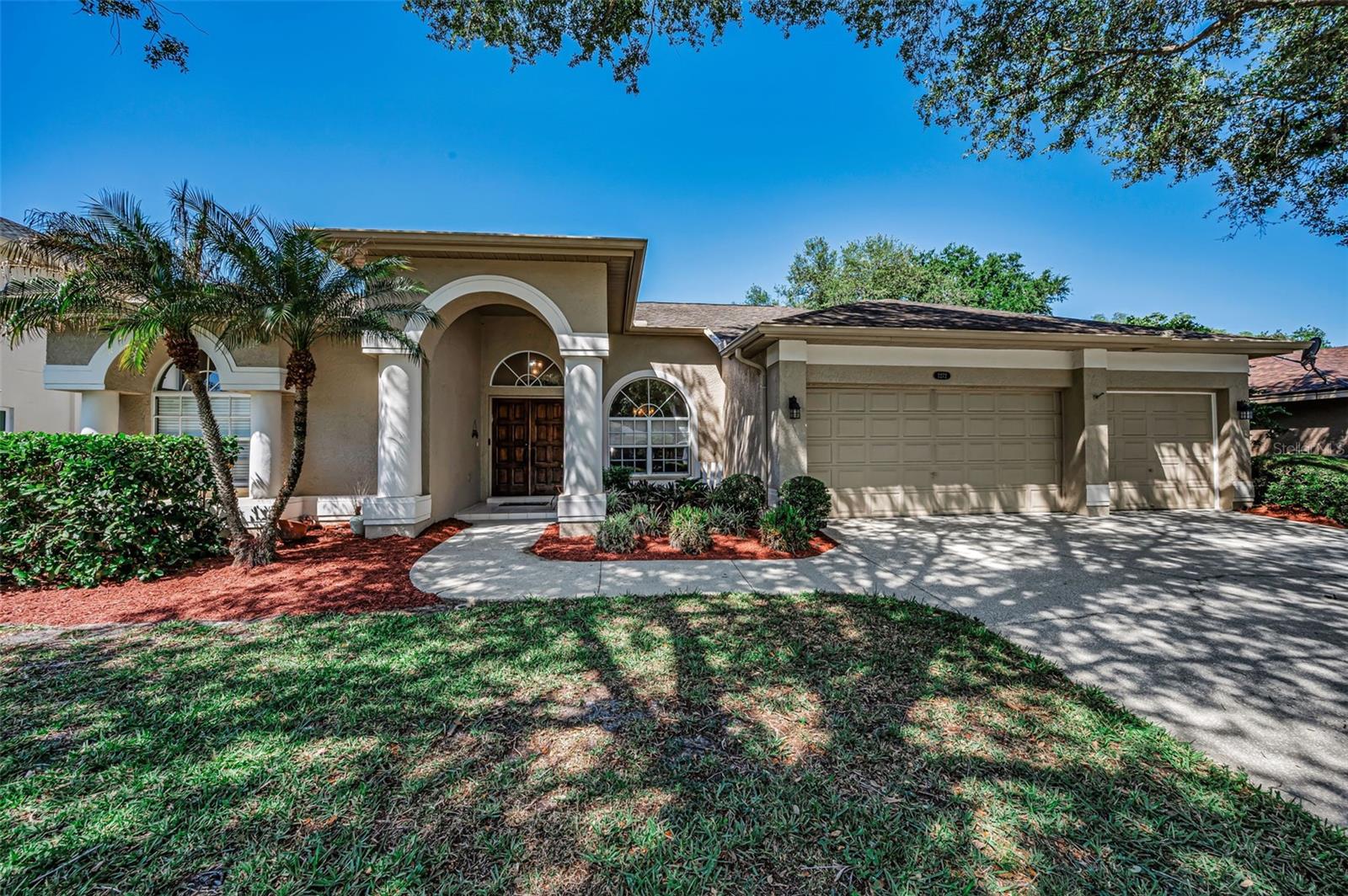 Welcome to 2272 Warwick Drive—where timeless elegance meets effortless Florida living. This well-maintained one-story home offers four spacious bedrooms, three full baths, a sparkling screened-in pool and a three-car garage. From the moment you arrive, stately columns and a grand double-door entry set the tone for what’s inside—soaring volume ceilings and an open, light-filled layout designed for both comfortable living and stylish entertaining. The living room is a true focal point, featuring a custom-built wall unit that adds both character and functionality. Peace of mind comes easy with a long list of recent updates, including a new HVAC system, water heater, and pool pump (2025), plus a resurfaced pool (2022) and new pool screens (2024). The beautifully updated eat-in kitchen is the heart of the home, featuring attractive maple cabinetry, granite countertops, a large center island and white appliances—including a new refrigerator (2026) and microwave (2025). Retreat to the oversized primary suite with its own sitting area—your private sanctuary—complete with a remodeled bath showcasing granite counters and refreshed cabinetry. Step outside and unwind in your private backyard oasis, where the pavered patio and screened pool overlooks the berm with no rear neighbors. Located in the exclusive Warwick Hills enclave within East Lake Woodlands, a 24/7 gated, resort-style community spanning 2,200 acres. Membership options available at the newly renovated Ardea Country Club. Indulge in championship golf, premier racquet facilities, a resort-style pool, fitness center, dining, and more. All of this, plus top-rated A schools and an unbeatable Oldsmar location just minutes to shopping, dining, parks, the Pinellas Trail, and Tampa International Airport—makes this home truly exceptional.