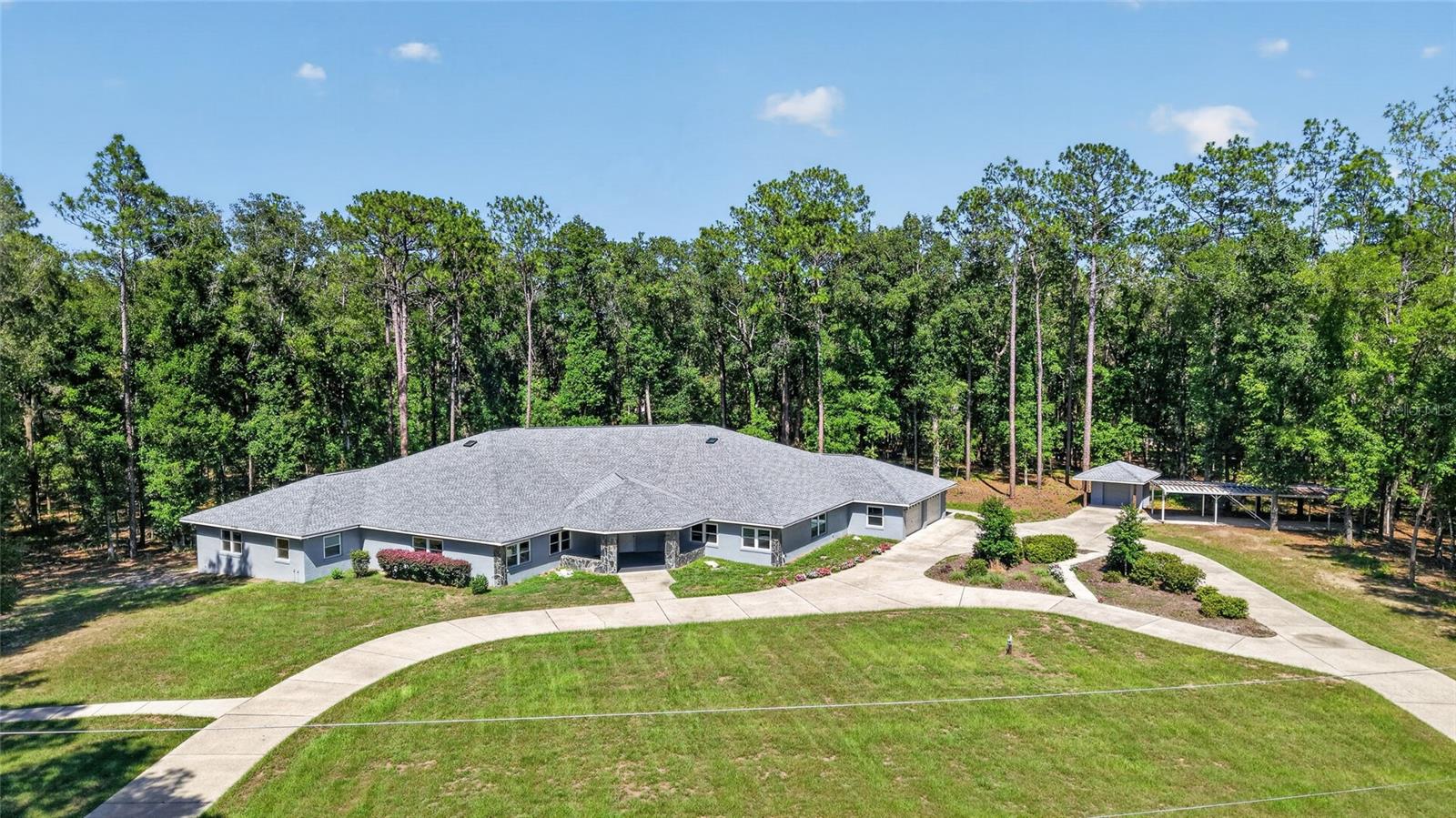 One-of-a-kind estate offering exceptional space, character and versatility. Tucked away at the end of a quiet cul-de-sac on 2.36 private acres in The Forest of Rainbow Springs, this custom-built residence offers nearly 5,700 square feet of living space designed for accessibility, flexibility and comfort. Thoughtfully created with barrier-free functionality, the home is handicap accessible and adaptable to a variety of lifestyles and future needs. The expansive floor plan features two primary suites, a full library and an oversized office complete with extensive built-in workstations, filing cabinets and storage. An interior efficiency apartment provides additional flexibility for guests, extended family or live-in assistance. With multiple living areas and private spaces, the home is ideally suited for multi-generational living, a home-based business or a private retreat. Designed for entertaining and culinary pursuits, the galley kitchen features two commercial-grade Sub-Zero refrigerators, double built-in ovens, two butler pantries and abundant storage and preparation space. Numerous built-ins, cabinetry, cupboards and storage systems throughout the home will remain, offering exceptional organization and functionality. Recent improvements include a new roof for the home and storage buildings in 2025, all new windows with interior custom casements and fresh exterior paint. two newer HVAC systems, two new water heaters, a newer water conditioning system, newer garbage disposal, new washer and dryer, and several newer appliances. The home also includes two built-in safes for secure storage. The oversized 29-by-31-foot garage offers generous storage and is complemented by an attached air-conditioned workshop. Two detached storage buildings with electricity and roll-up doors provide additional space for equipment, hobbies, projects or business operations. Additional features include two electrical panels, a Generac 20-kilowatt whole-house generator supported by a 250-gallon underground propane tank and a dual-system climate control setup. One HVAC system includes an Aquafer system that converts hot steam into hot water. Surrounded by mature trees, established landscaping and abundant wildlife, the property offers exceptional privacy and a peaceful natural setting. Whether envisioned as a multi-generational residence, creative studio, private business headquarters or personal retreat, the possibilities are extensive. Residents of The Forest of Rainbow Springs enjoy an impressive collection of amenities with a low annual homeowners association fee, including a clubhouse, community pool, pickleball courts, tennis courts, basketball court, bocce ball, driving range, restaurant, disc golf course and recreational trails. The community also offers access to a private three-acre river park approximately 1,500 feet by kayak or canoe from the headwaters of Rainbow Springs State Park. Amenities include a private swimming area, kayak launch, pavilions, barbecue grills, restrooms, outdoor showers and on-site security. Conveniently adjacent to Juliette Falls Golf Club and within easy reach of Ocala, Gainesville, Tampa and Orlando, this distinctive property combines privacy, functionality, extensive updates and exceptional community amenities in one remarkable offering.