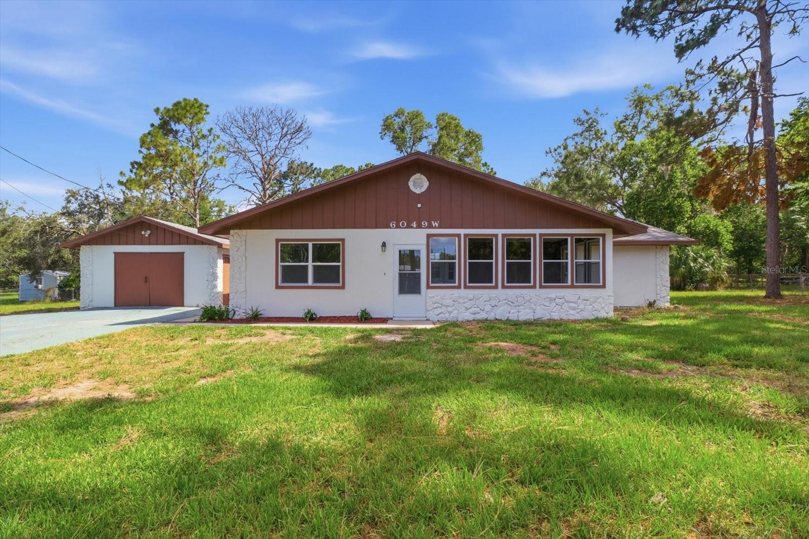 Virtually Staged. 3 BEDROOM, 2 BATH HOME REIMAGINED FOR MODERN LIVING ON 2.42 ACRES (APPROX) IN THE HEART OF THE NATURE COAST! Move-in ready and beautifully renovated, this home sits on almost 2.5 acres in Homosassa, Florida, with a detached garage and a clean, modern look throughout. The popular split floor plan places the Primary Suite on one side and guest rooms on the other for maximum privacy, while open common areas tie it all together. The kitchen is a showstopper, featuring brand-new cabinets, quartz countertops, stainless appliances, a breakfast bar, and a spacious center island with sink, all set up for entertaining. The open-concept great room makes hosting easy, and cozy evenings by the fireplace are calling your name. When the Florida evening shade rolls in, head to the screened porch and take in the view of your own slice of nature. The Primary Suite features a bright, updated bath. Guest rooms are generously sized, as well, so your guests can also relax in comfort. A heated and cooled front sunroom offers even more room to relax or entertain. New windows and doors throughout. Roof in 2021. The detached garage is ready for parking, storage, or a workshop for the tinkerer. All this on a paved road with no deed restrictions, well and septic (no monthly water/sewer bills), and zoned for Lecanto Primary, Middle, and High Schools. No HOA! Convenient to shopping, dining, and medical care, with easy access to the Suncoast Parkway and about an hour to Tampa International Airport. And of course, Homosassa is the heart of the Nature Coast, with fishing, boating, springs, and forests all just minutes away. 3D Tour in links! Come see this one, today!