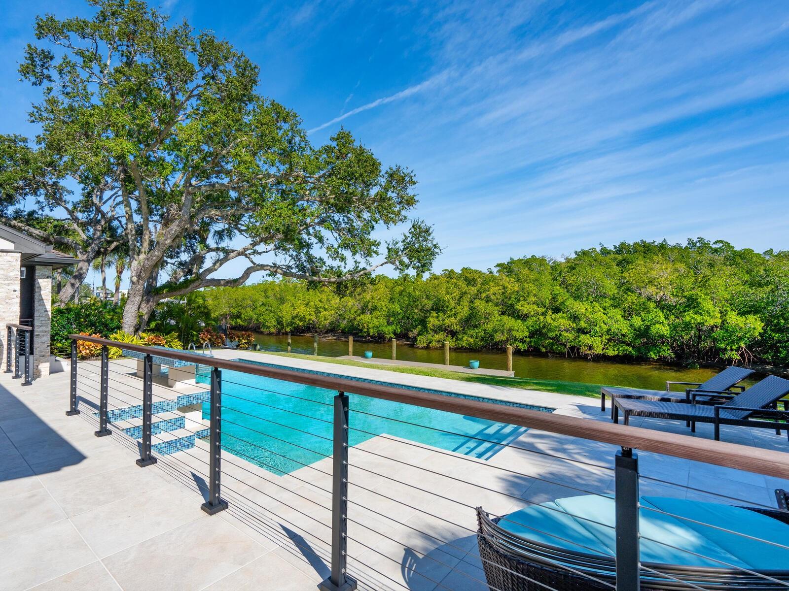 A luxurious waterfront retreat; welcome to paradise. Nestled in a coveted Siesta Key neighborhood just a leisurely .6 miles to the world-renowned Siesta Beach, this stunning home epitomizes coastal living with its direct bay boating access. Built for refined comfort and entertaining, this home was completely transformed in 2017. High clerestory windows allow ample morning light under a 19-foot wood-beamed vaulted ceiling. A sculpted wood wall anchors the living room, accentuated by the electric fireplace, adding to the casual contemporary elegance. The heart of the home, the spectacular kitchen, features vaulted shiplap ceilings, custom rift oak cabinets, quartz counters, Bosch appliances, a wine fridge, and an oversized island, perfect for gatherings. The first floor boasts three bedrooms, two with en-suite baths, showcasing exceptional finishes, while a third doubles as an office with a loft. A large, fully outfitted laundry room adds convenience. Ascend the custom-designed wood staircase to the private primary suite on the second floor, offering a sitting area and a covered balcony to relish the water view, beautiful sunrises, and balmy bay breezes. The en-suite bath is a true sanctuary offering a coffee bar, dual sinks, a soaking tub, a glass-enclosed steam shower, and ample storage. Descend the staircase to the first level and step through impact glass doors to the covered lanai overlooking the oversized, sparkling pool surrounded by porcelain pavers for seamless indoor-outdoor living. The outdoor kitchen, wood tongue-and-groove vaulted ceiling, motorized retractable insect screens, and lush tropical landscaping create an inviting oasis. Enjoy direct access to Sarasota Bay and the Intracoastal Waterway from your Trex dock for endless boating, kayaking, and paddleboarding adventures. Meet dolphins and manatees up close and be mesmerized by the vast array of beautiful waterfowl. This meticulously designed home seamlessly blends luxury, comfort, and waterfront living, offering a rare opportunity to own a slice of paradise in Siesta Key. Don’t miss your chance to experience the epitome of island living. You can have it all - mere steps from the open bay and close to the powdery white quartz sands of Siesta Beach and the azure waters of the Gulf of Mexico. Enjoy the convenience of being close to Siesta Village, offering an array of dining, shopping, and entertainment options. Only 15 minutes to the mainland to experience vibrant downtown Sarasota's dining, shopping, and entertainment offerings. Bedroom Closet Type: Walk-in Closet (Primary Bedroom).