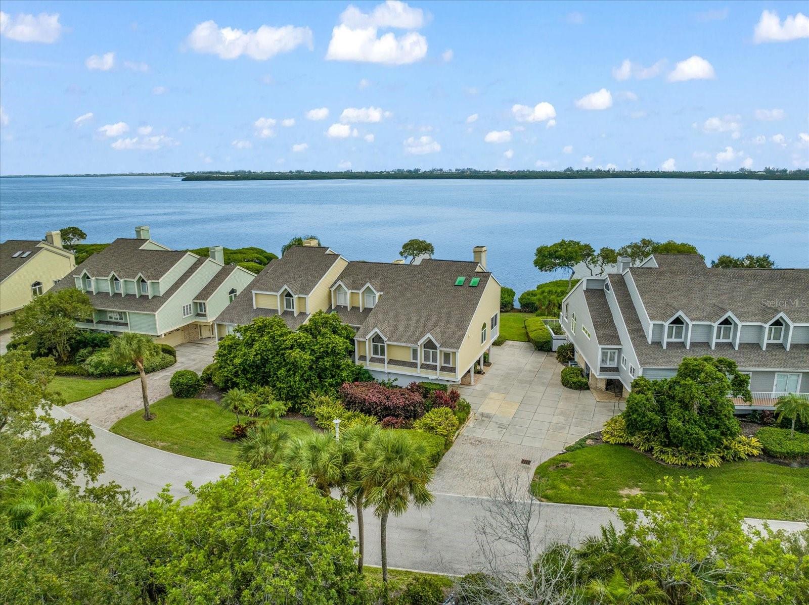 Ideal coastal retreat nestled in the heart of Sarasota Bay. This immaculate 3-level townhome, boasting panoramic views of the bay, has been meticulously updated with an updated kitchen and contemporary baths, ensuring a seamless blend of modern comfort and timeless elegance. With a spacious dining room adorned with vaulted ceilings and an inviting ambiance, this home is perfect for hosting intimate gatherings or enjoying quiet family dinners. Step inside to discover the seamless flow of wood floors throughout, exuding warmth and sophistication at every turn. The allure continues with a large balcony offering breathtaking vistas, as well as a charming screened porch for those cozy moments. This home features 2 bedrooms with an additional loft space, providing ample room for relaxation and privacy. Unwind and entertain effortlessly with the convenience of a well-equipped wet bar, while the 2-car garage and storage room offer practical solutions for all your storage needs. Situated on the desirable west end of the island, this community offers a host of exclusive amenities, including access to inviting pools, a soothing spa, scenic trails for leisurely strolls, and welcoming gathering spaces for fostering connections with neighbors. With 24/7 gated security, you can enjoy peace of mind and security throughout the year. Embrace the local culture and heritage with easy access to the nearby history museum, or explore the natural wonders of the bay with a boardwalk and kayak launch just steps away. Convenience is at your fingertips, with the pristine beaches, the SRQ airport, and the bustling downtown area all within easy reach. This townhome presents an unrivaled opportunity to live the quintessential coastal lifestyle you've been dreaming of. Seize the chance to experience the best of Sarasota Bay living - schedule a viewing today and unlock the door to your new chapter of serene coastal living. Two Brand New A/C UNITS 10/2025